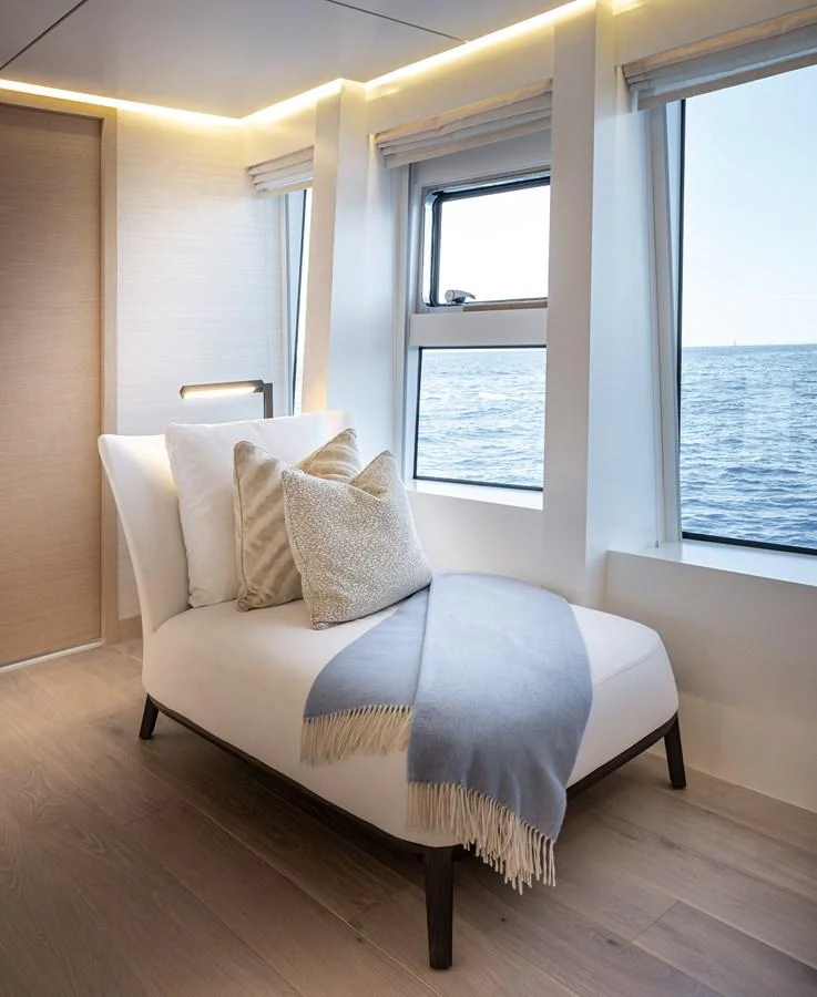 A serene interior space featuring a comfortable lounge chair with a view of the sea through large windows. aboard NUMARINE 37XP#22 Yacht for Sale