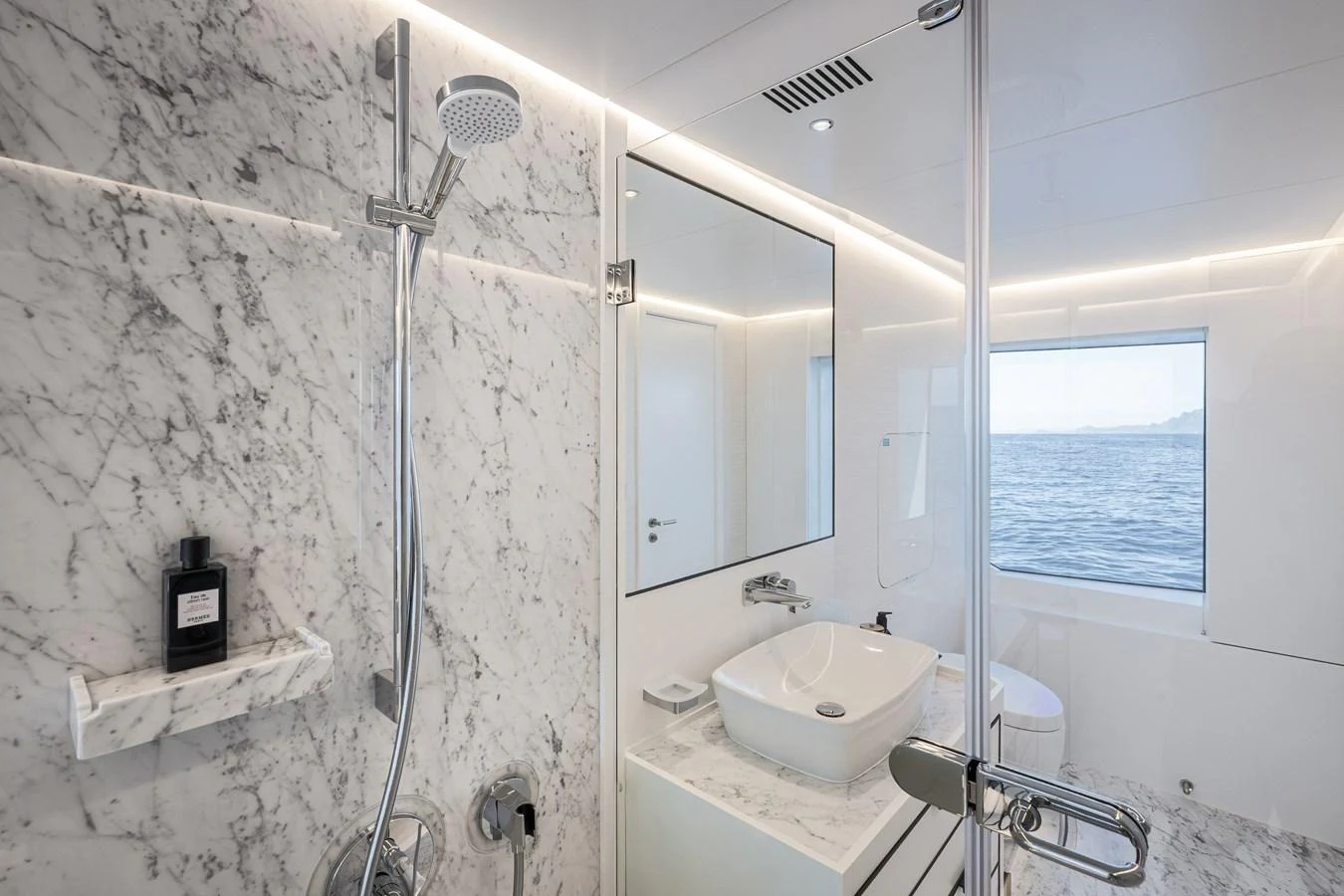 The yacht's bathroom features elegant marble surfaces and a large window with a sea view. aboard NUMARINE 37XP#22 Yacht for Sale