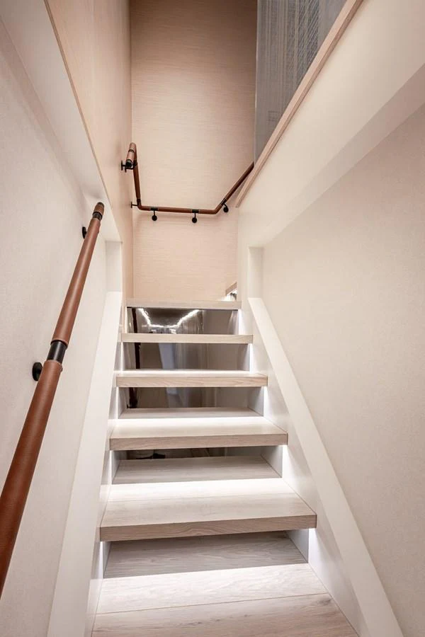 A modern staircase with sleek handrails and ambient lighting leads to the upper deck. aboard NUMARINE 37XP#22 Yacht for Sale