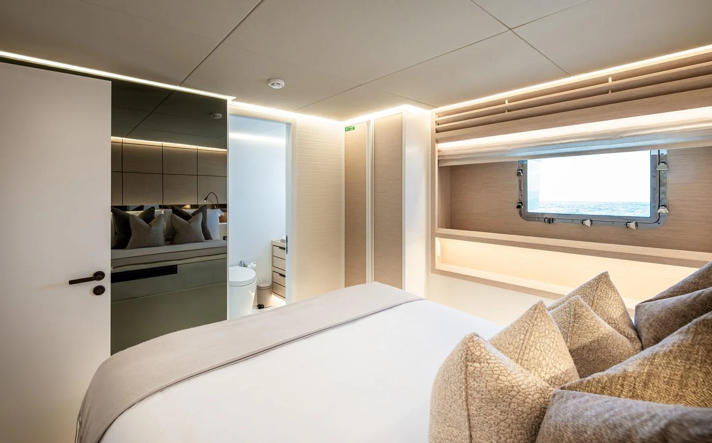 The stateroom features a plush bed with elegant bedding and a window offering a serene view of the sea. aboard NUMARINE 37XP#22 Yacht for Sale