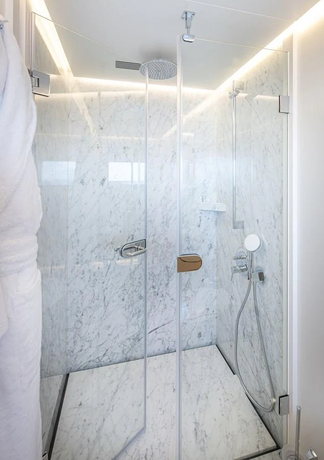 The bathroom features a sleek, modern shower with marble walls and a glass door. aboard NUMARINE 37XP#22 Yacht for Sale