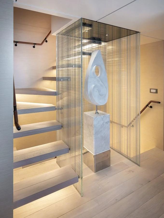 A modern staircase with a sleek design and an artistic sculpture enhances the yacht's interior elegance. aboard NUMARINE 37XP#22 Yacht for Sale