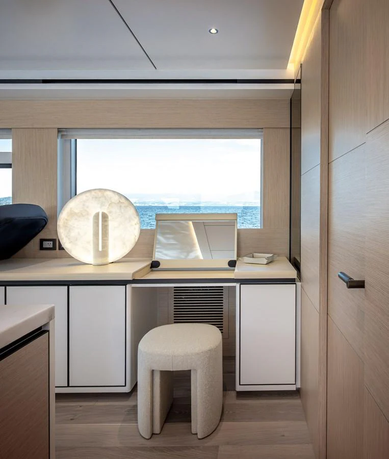 A serene interior space featuring a vanity area with a large round mirror and a comfortable stool. aboard NUMARINE 37XP#22 Yacht for Sale