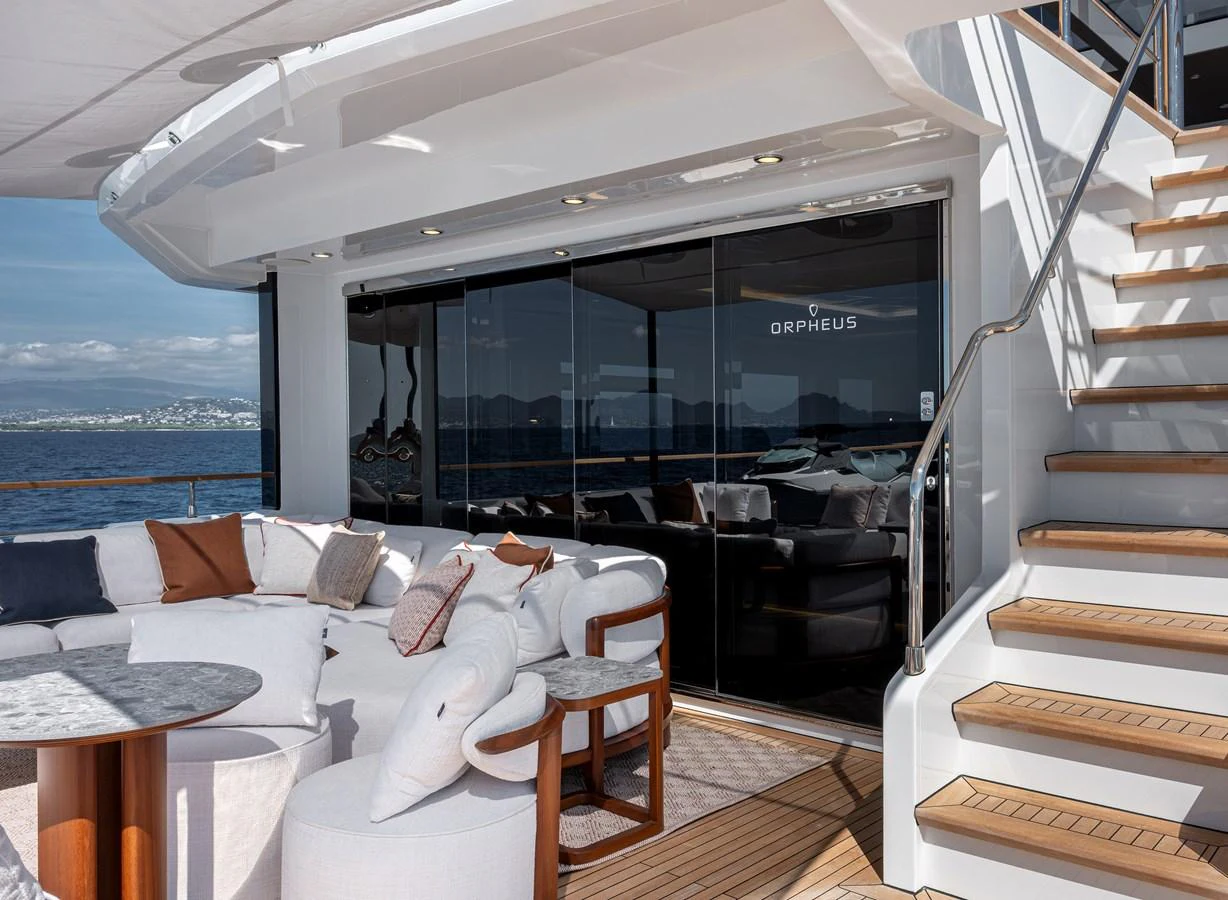 The aft deck features a luxurious seating area with plush white cushions and a staircase leading to the upper deck. aboard NUMARINE 37XP#22 Yacht for Sale