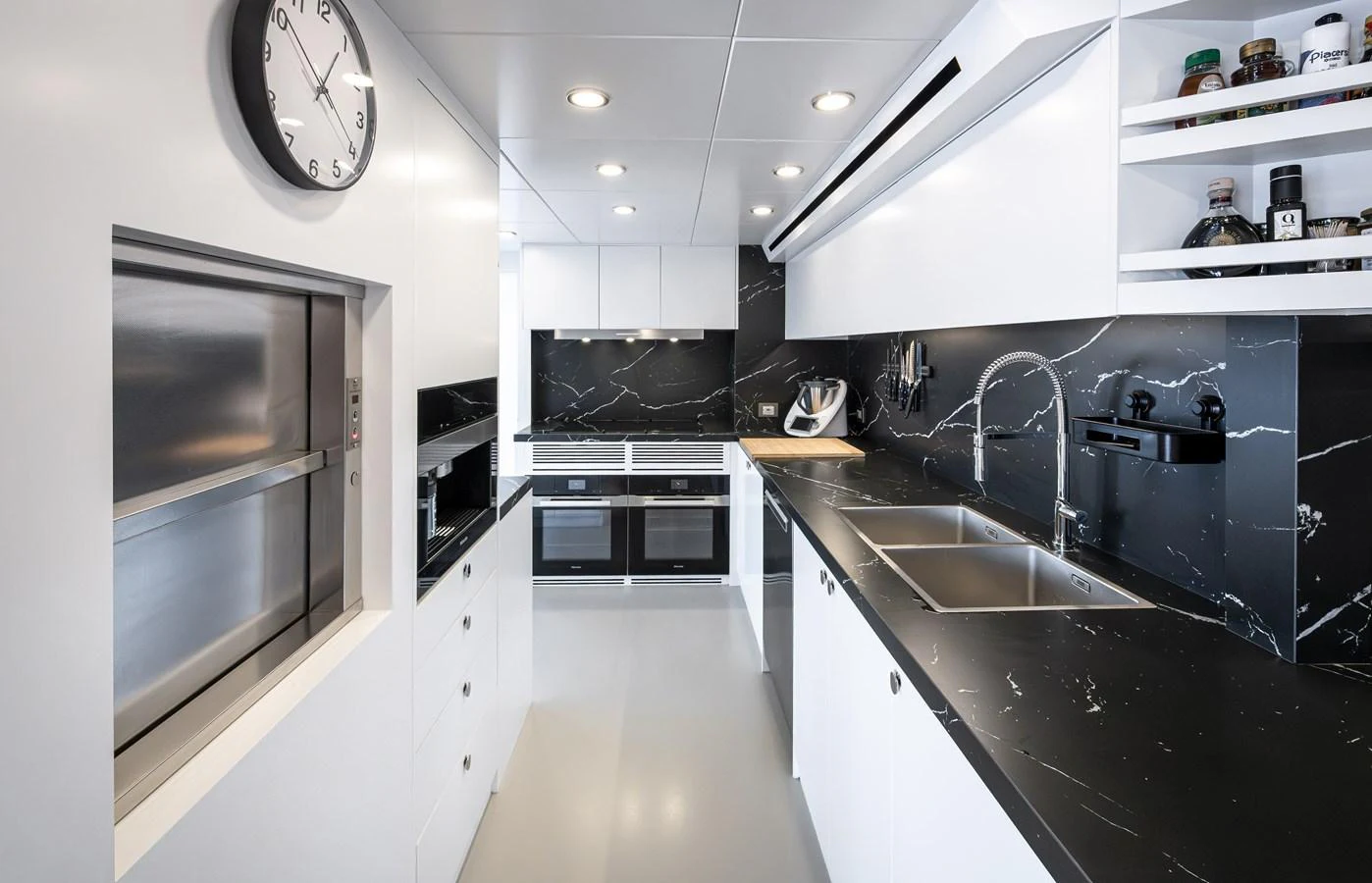 The yacht's galley features sleek black and white decor with modern appliances and ample counter space. aboard NUMARINE 37XP#22 Yacht for Sale