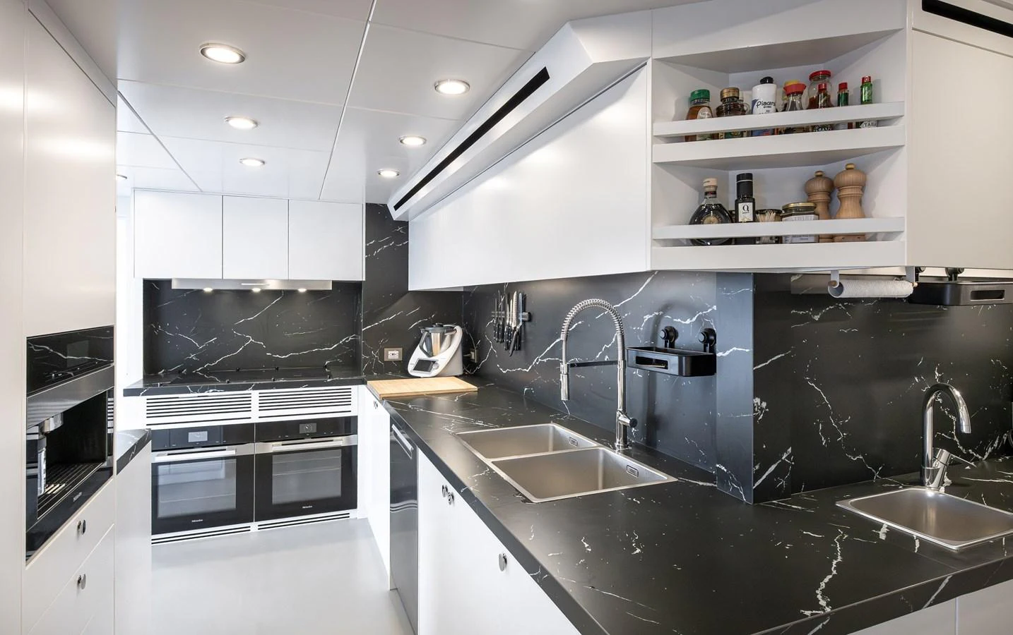 The yacht's galley features sleek black marble countertops and modern appliances, creating a sophisticated culinary space. aboard NUMARINE 37XP#22 Yacht for Sale