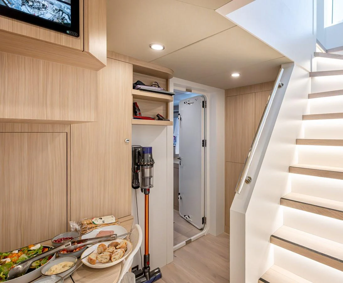 A well-lit interior space featuring a staircase, a dining area, and storage compartments. aboard NUMARINE 37XP#22 Yacht for Sale
