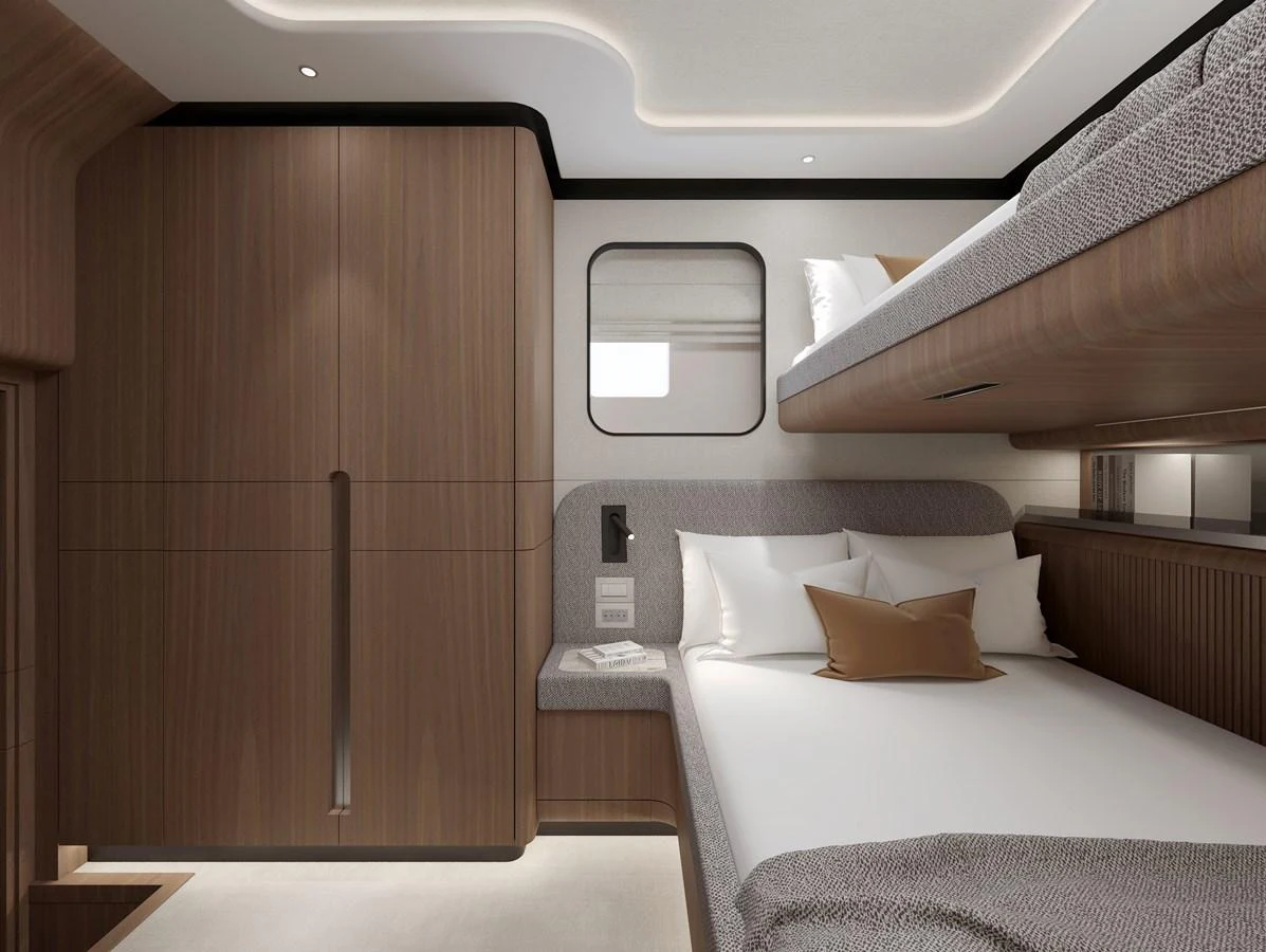 The guest cabin features a cozy double bed with a bunk above, complemented by modern wood paneling and soft lighting. aboard B77 Yacht for Sale