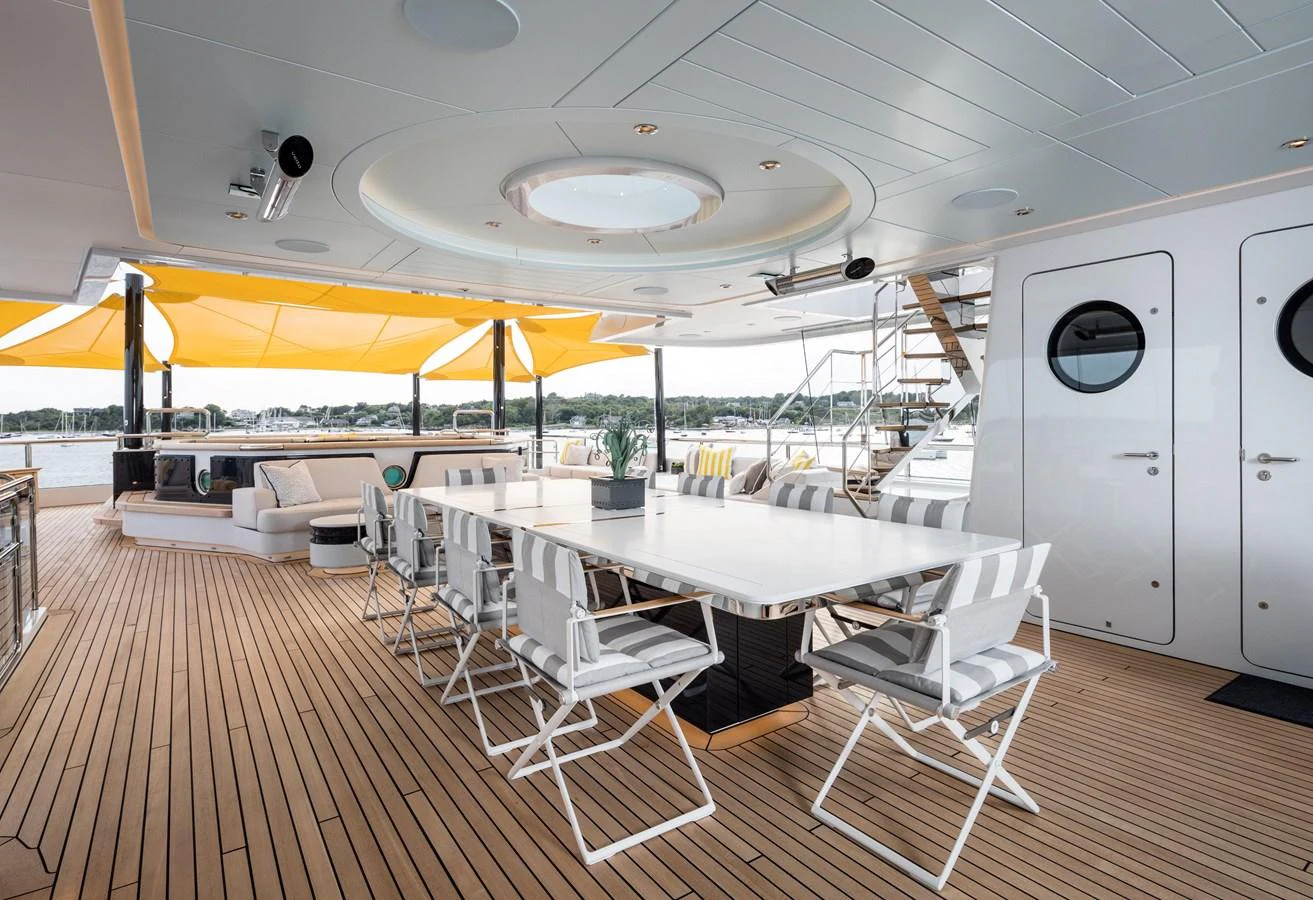 The aft deck features a spacious dining area with a large table and comfortable seating, perfect for alfresco meals. aboard SCOUT Yacht for Sale