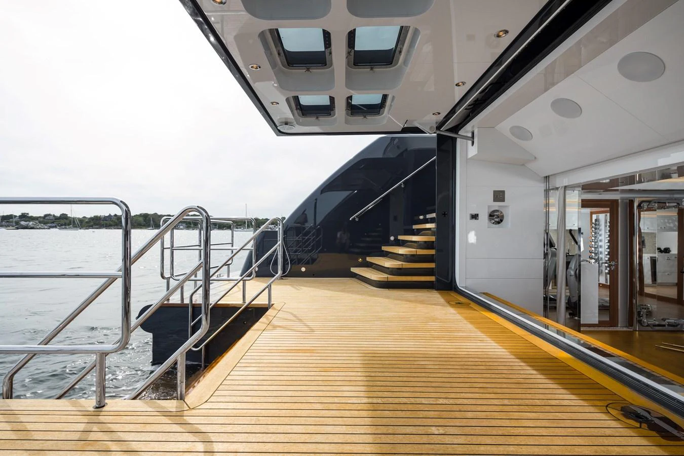 The aft deck features a spacious and modern design with sleek stairs leading to the upper level. aboard SCOUT Yacht for Sale