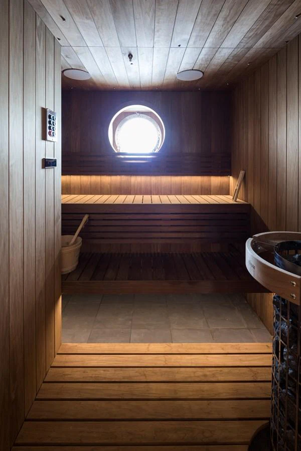 A cozy wooden sauna with a porthole window offers a relaxing retreat. aboard SCOUT Yacht for Sale