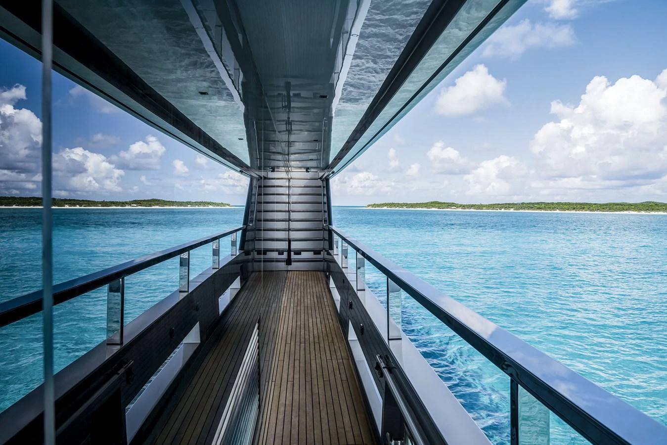 The side deck offers a serene view of the turquoise waters and distant shoreline. aboard RIVA 130/02 Yacht for Sale