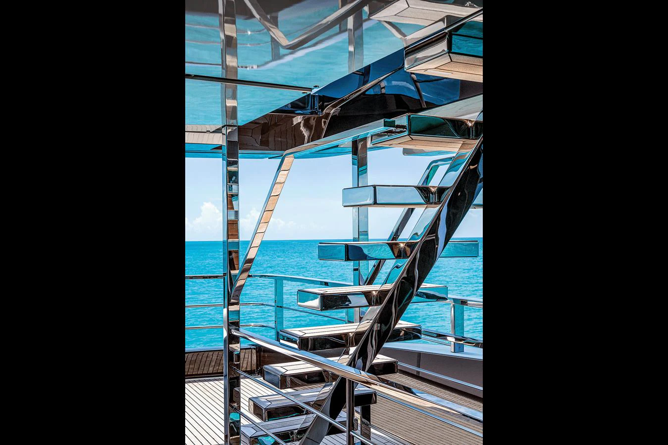 A sleek, modern staircase with reflective surfaces offers a stunning view of the ocean. aboard RIVA 130/02 Yacht for Sale