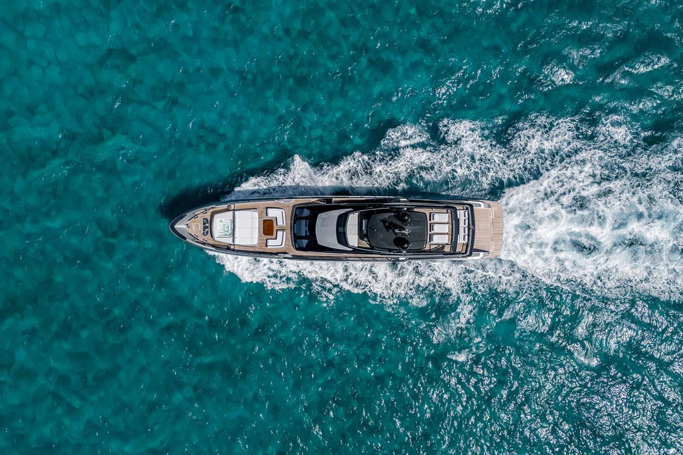 A sleek yacht cruises through vibrant blue waters, showcasing its elegant design from an aerial perspective. aboard RIVA 130/02 Yacht for Sale