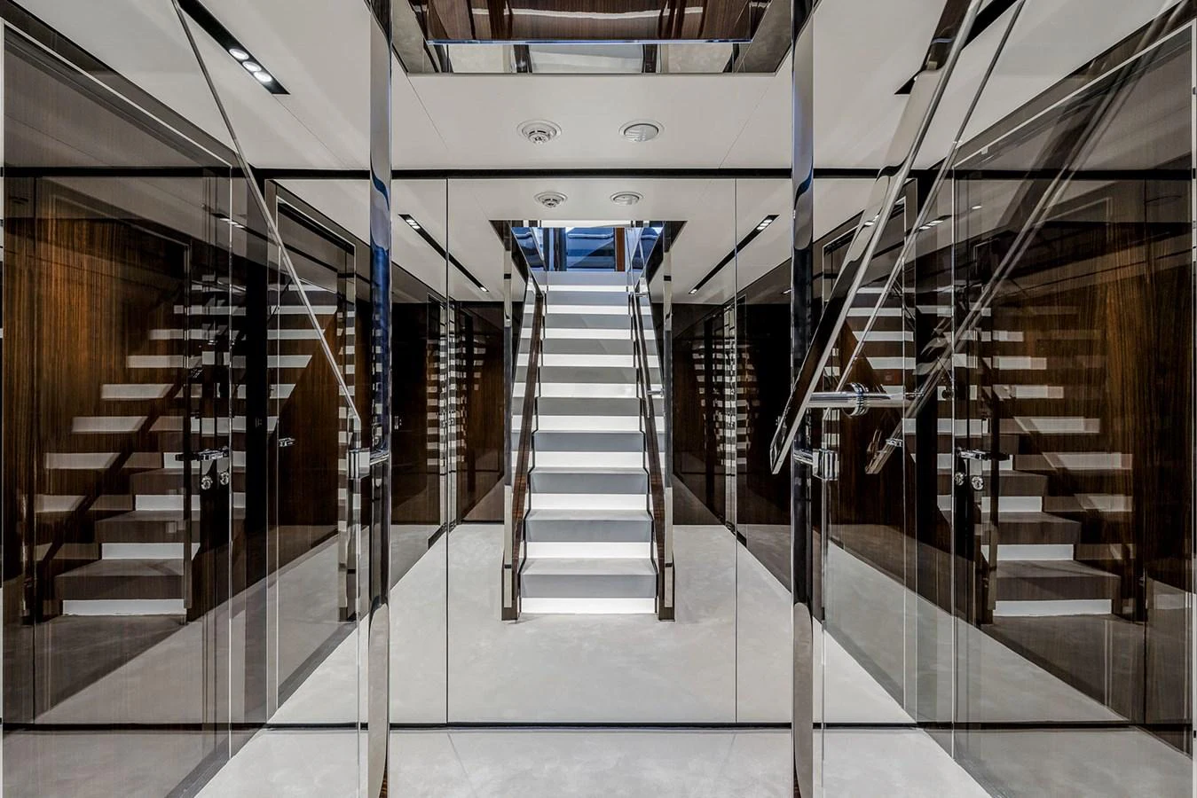 A sleek and modern interior featuring a central staircase with mirrored walls. aboard RIVA 130/02 Yacht for Sale