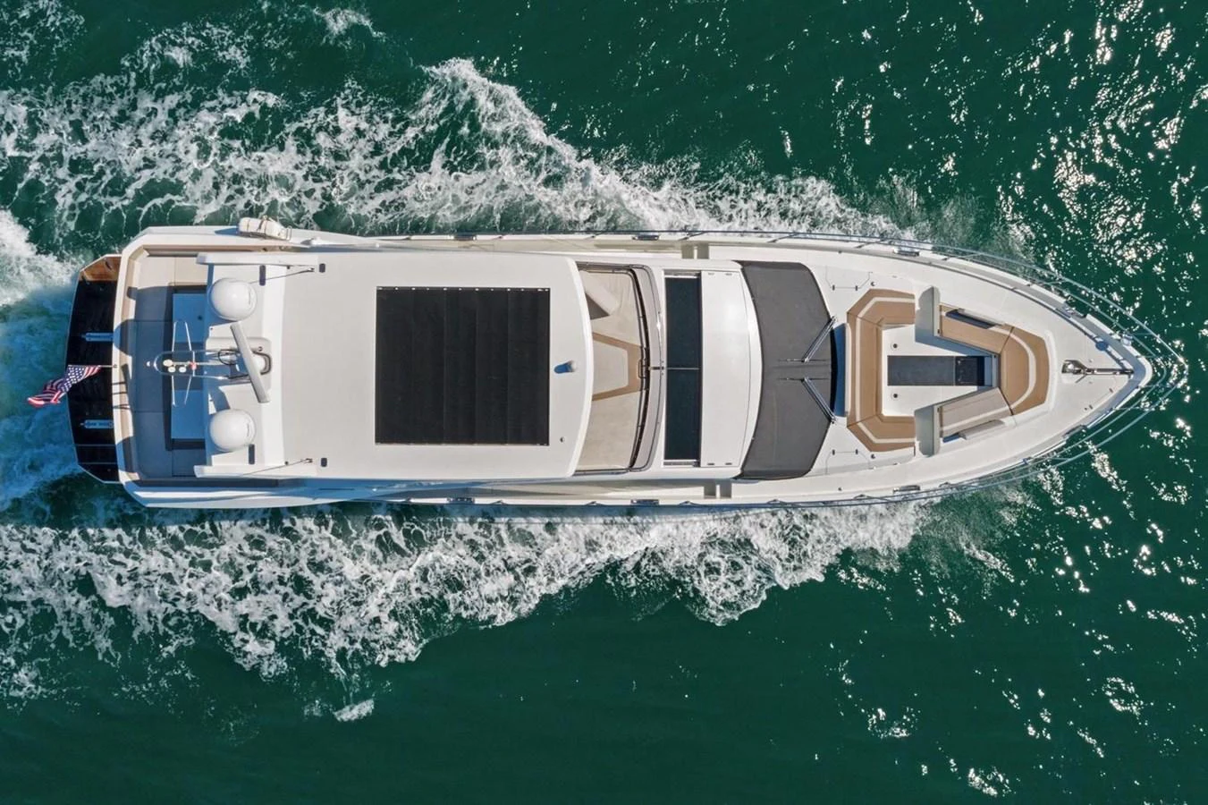 An aerial view of a sleek yacht cruising through the water, showcasing its spacious deck and modern design. aboard GALEON Yacht for Sale