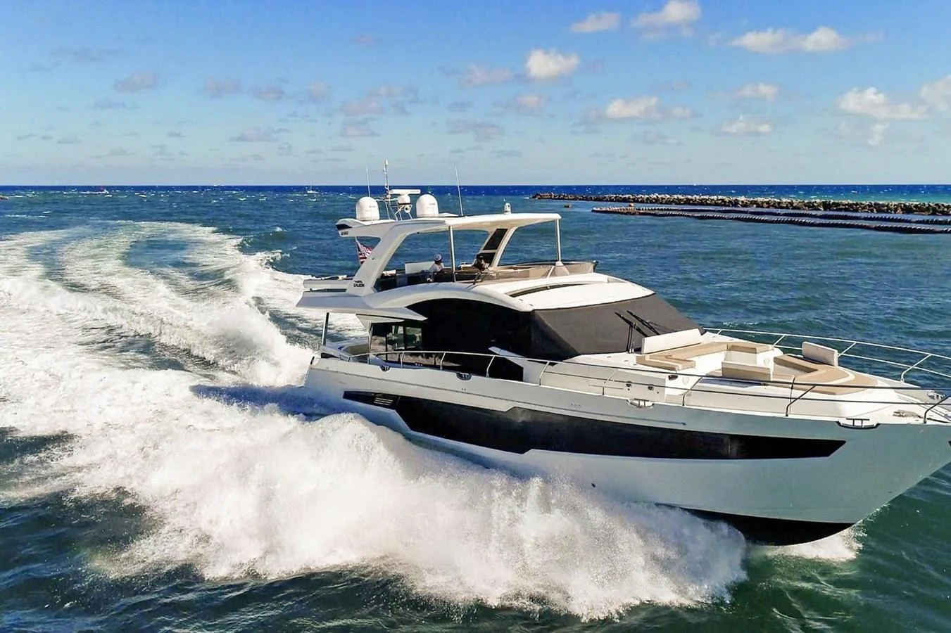 A sleek yacht cruises swiftly through the open water, showcasing its modern design and powerful performance. aboard GALEON Yacht for Sale