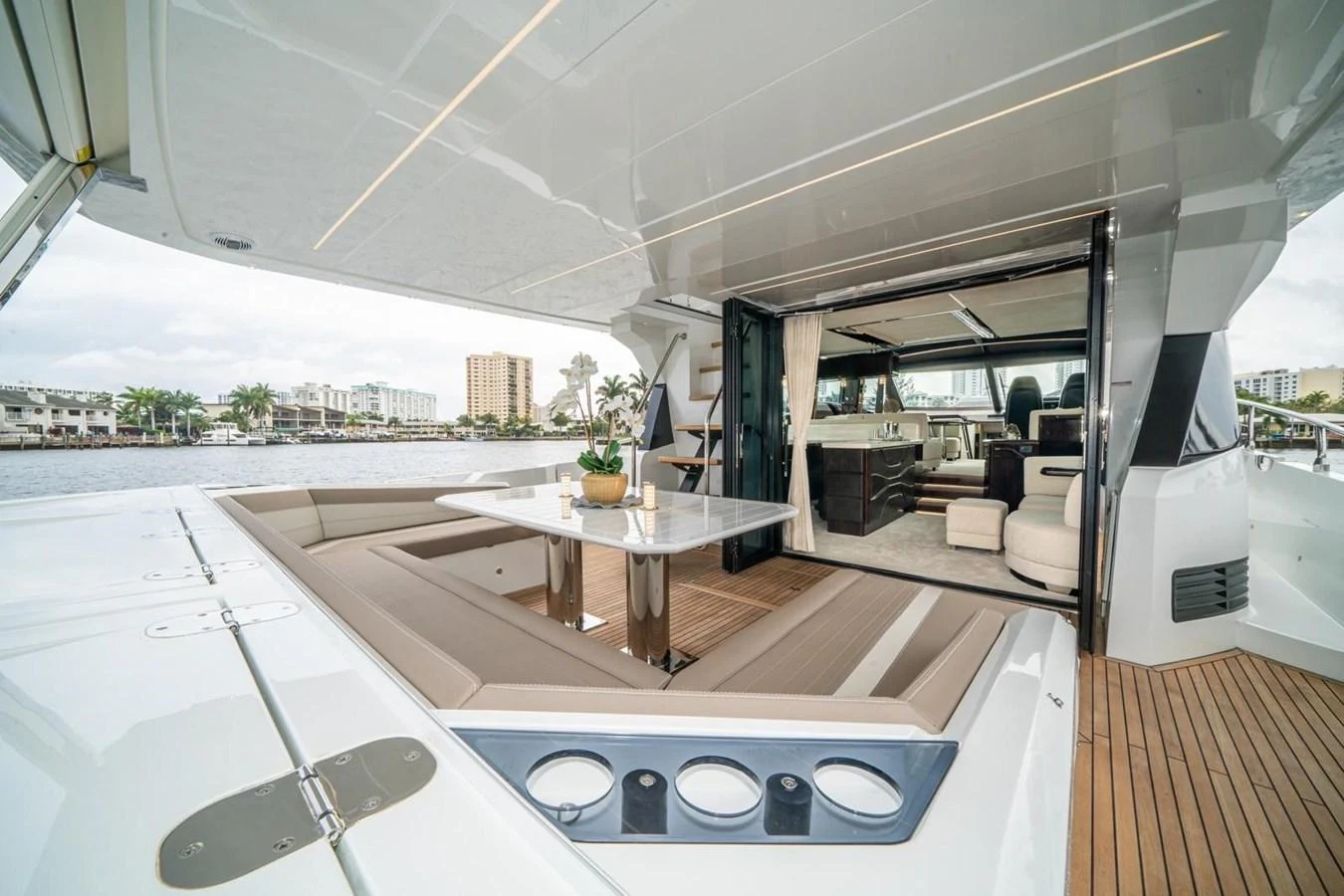 The aft deck features a spacious seating area with a sleek dining table, seamlessly connecting to the luxurious interior. aboard GALEON Yacht for Sale