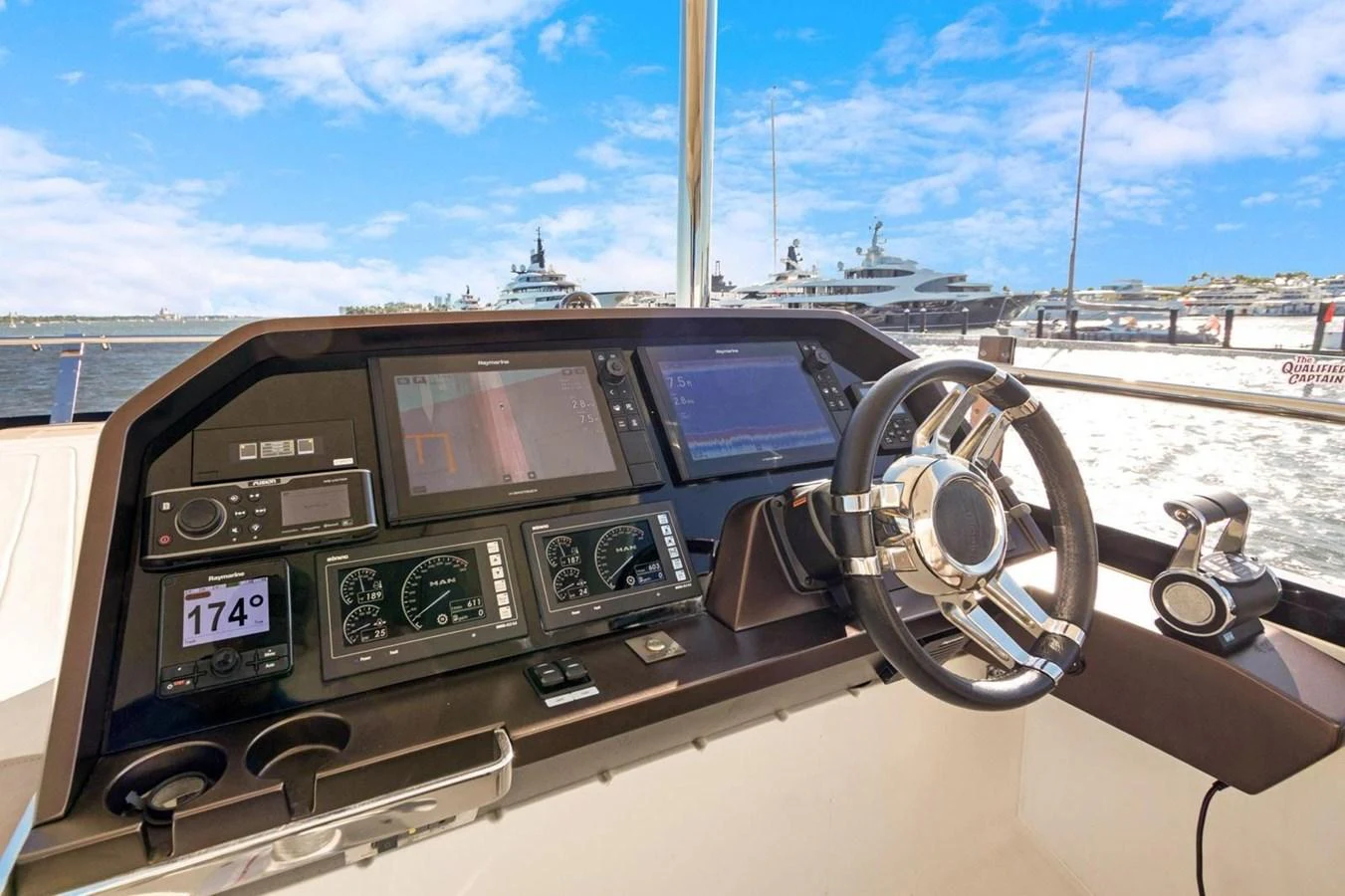 The helm station features advanced navigation equipment and a sleek steering wheel, offering a commanding view of the marina. aboard GALEON Yacht for Sale