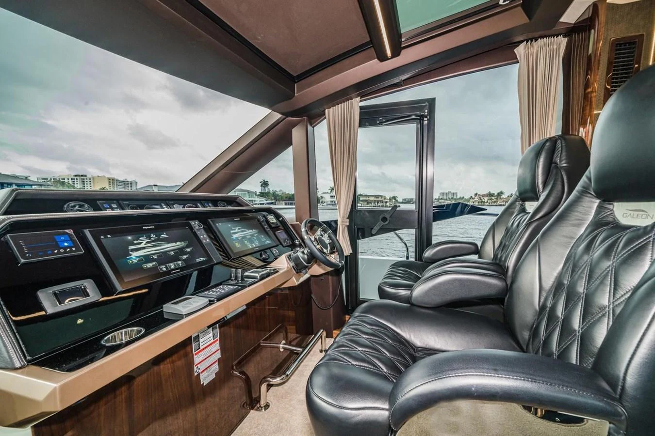 The helm station features luxurious leather seating and advanced navigation systems, offering a commanding view of the surroundings. aboard GALEON Yacht for Sale