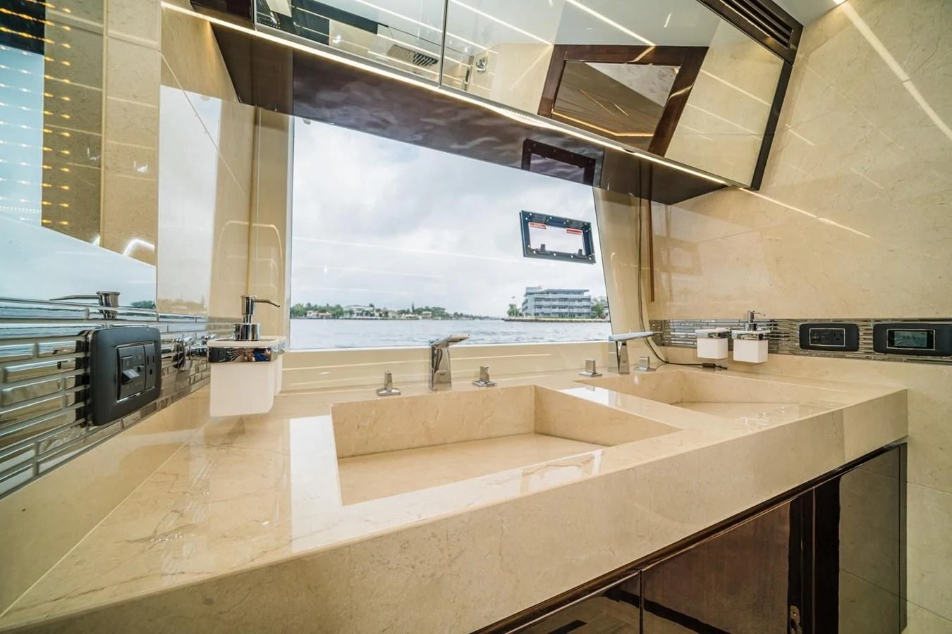 The yacht's bathroom features a luxurious double sink with a large window offering a scenic view. aboard GALEON Yacht for Sale