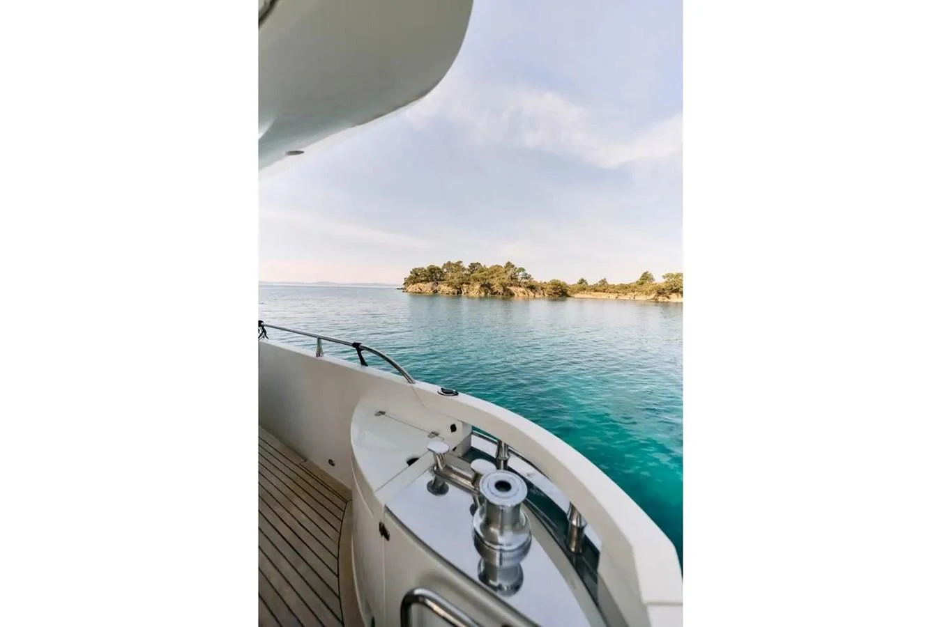 The yacht's deck offers a serene view of the surrounding turquoise waters and distant shoreline. aboard MARQUIS 720 Yacht for Sale