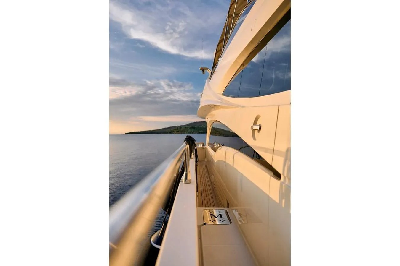 A serene view along the side deck of a yacht, showcasing the sleek design and calm waters. aboard MARQUIS 720 Yacht for Sale