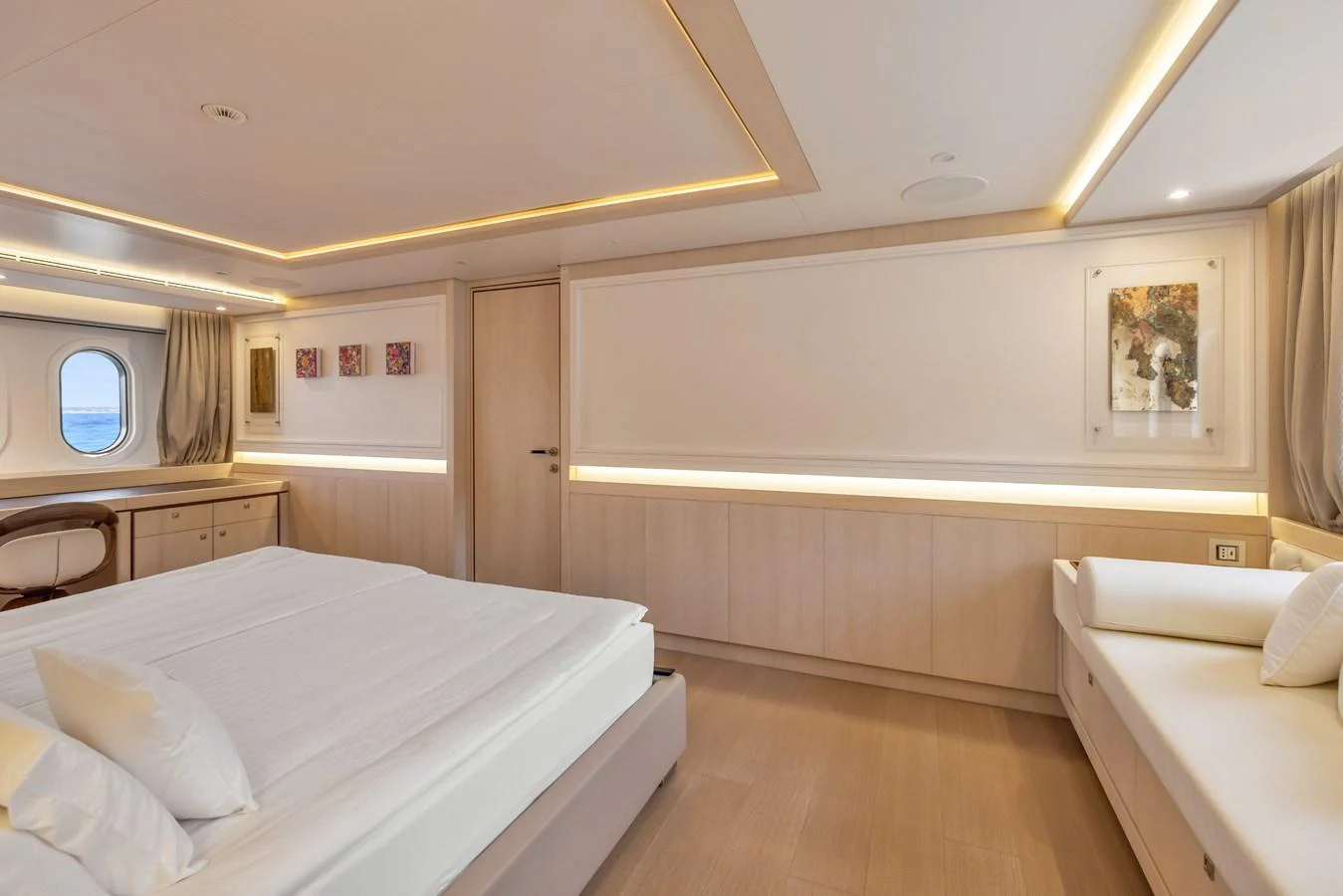 A luxurious stateroom featuring a large bed, a seating area, and elegant lighting. aboard VANADIS Yacht for Sale
