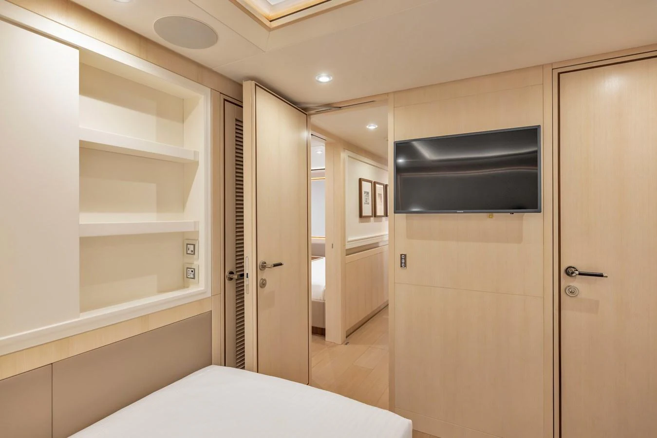 A cozy and modern yacht cabin featuring a flat-screen TV and ample storage space. aboard VANADIS Yacht for Sale
