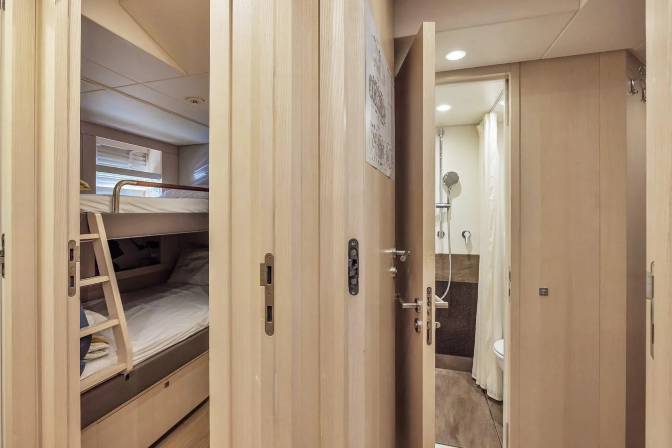 The image showcases a cozy guest cabin with bunk beds and an adjacent bathroom. aboard VANADIS Yacht for Sale