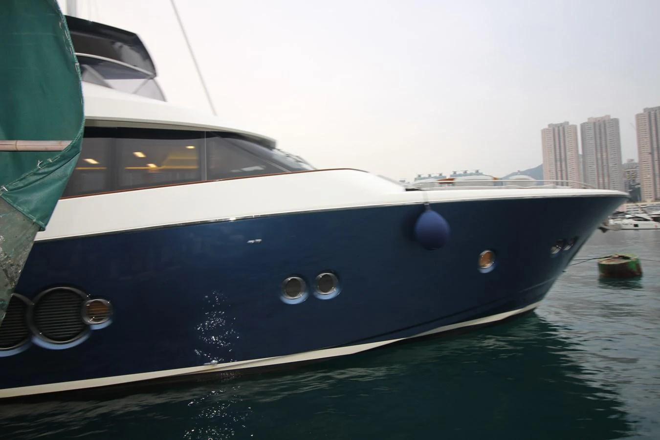 A sleek yacht with a blue hull docked in a marina. aboard AURORA Yacht for Sale