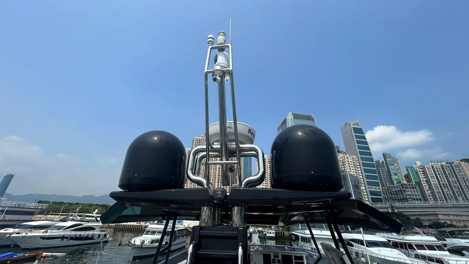 The image showcases the yacht's advanced radar and communication equipment against a cityscape backdrop. aboard AURORA Yacht for Sale