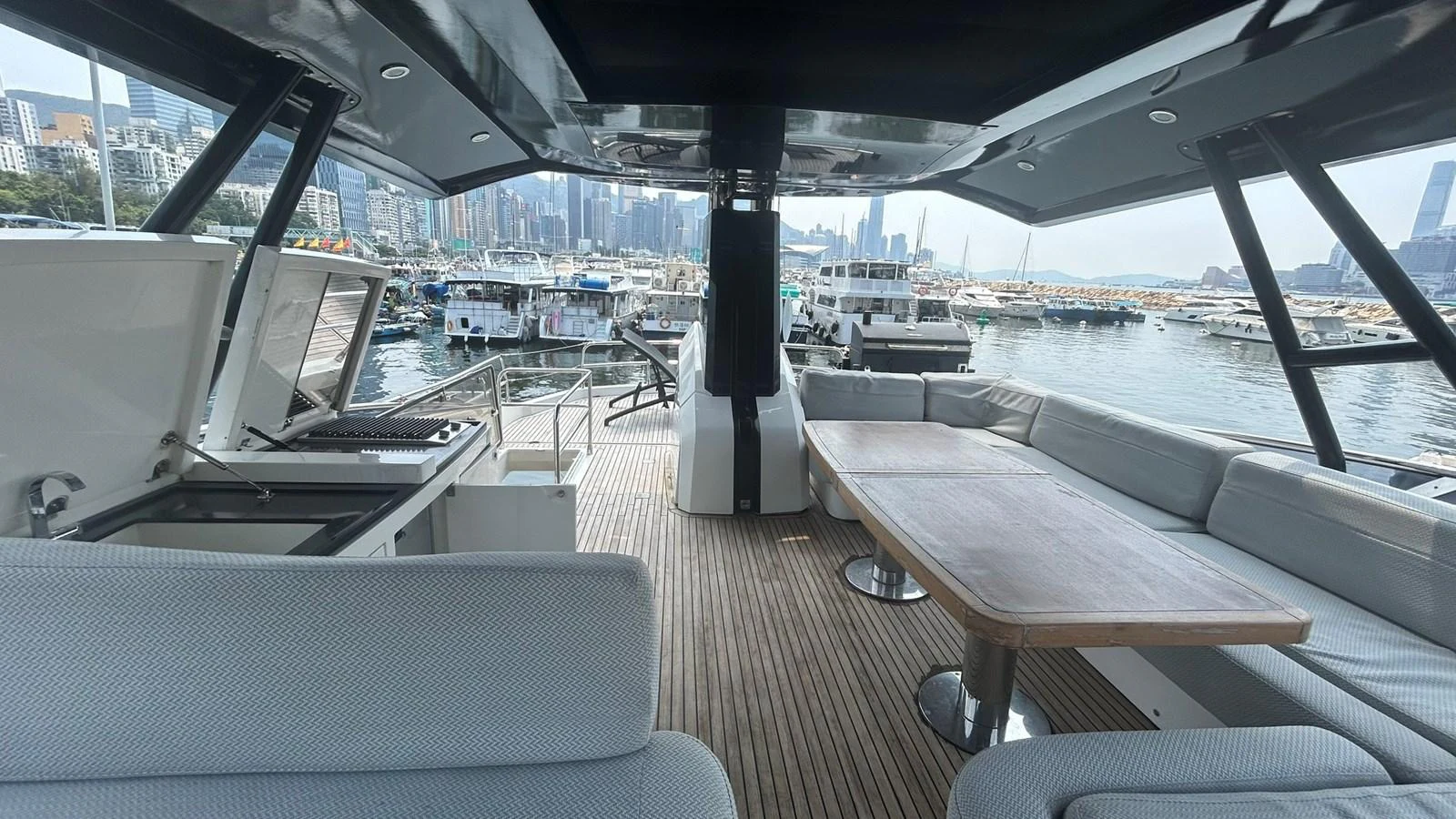 The aft deck features a spacious seating area with a wooden table, perfect for outdoor dining and relaxation. aboard AURORA Yacht for Sale