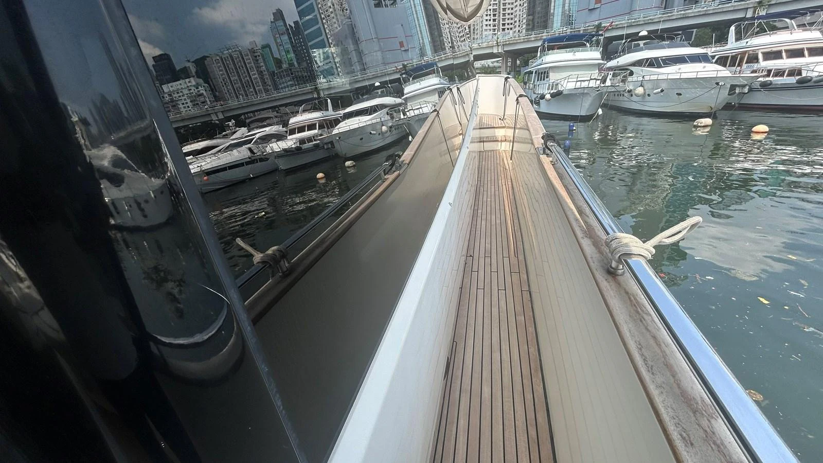 The yacht is docked in a marina, showcasing its sleek side deck and the surrounding boats. aboard AURORA Yacht for Sale