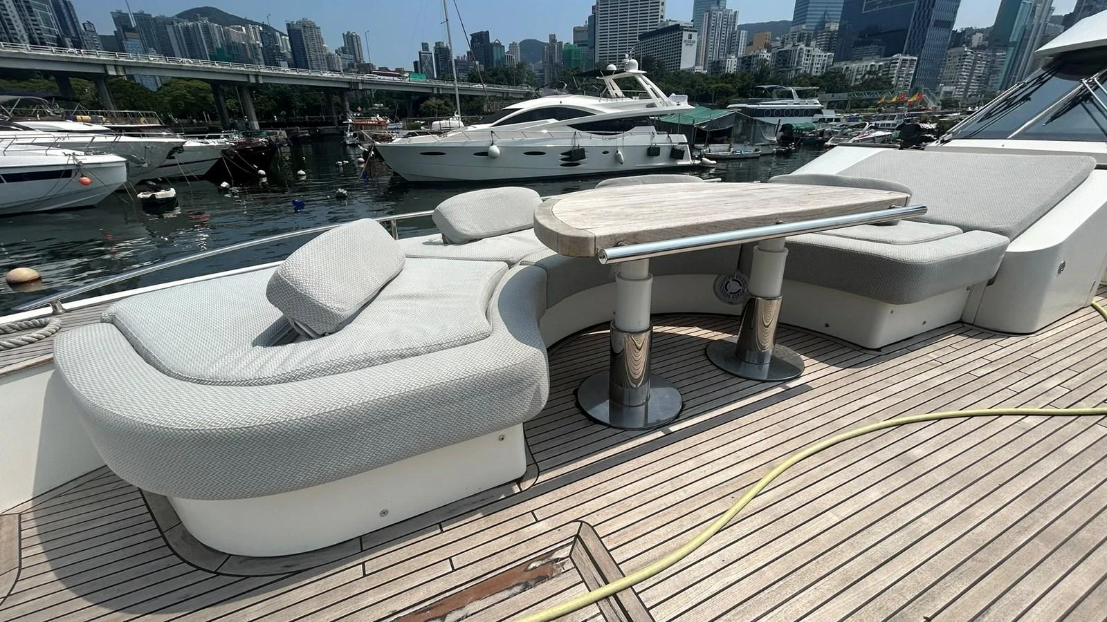 The aft deck features a stylish seating area with a wooden table, perfect for outdoor relaxation. aboard AURORA Yacht for Sale