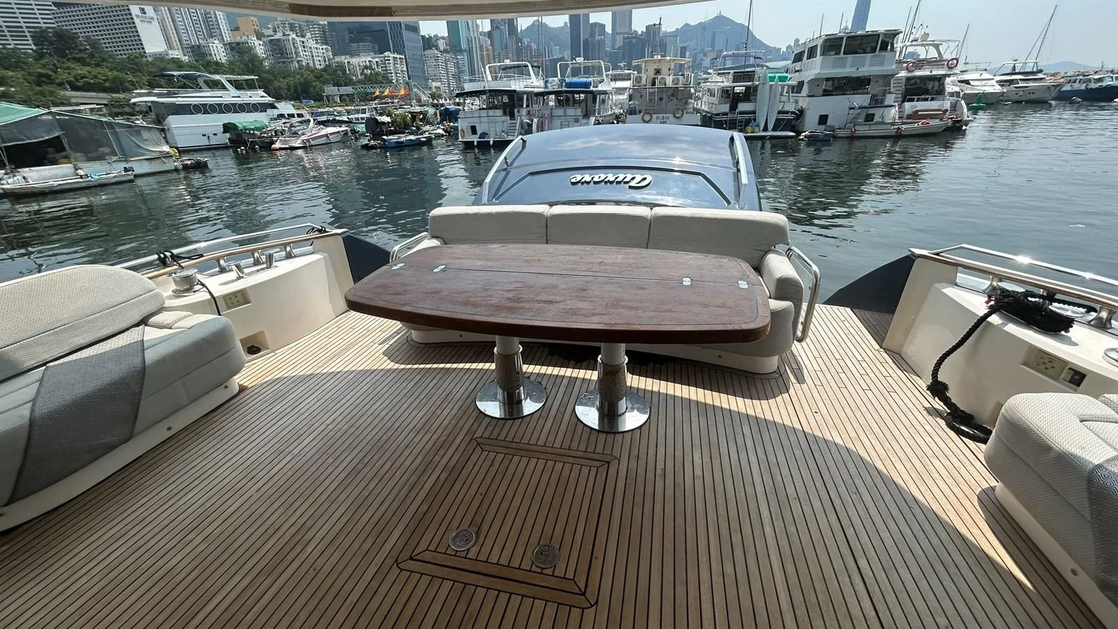 The aft deck features a spacious seating area with a wooden table, perfect for outdoor dining and relaxation. aboard AURORA Yacht for Sale