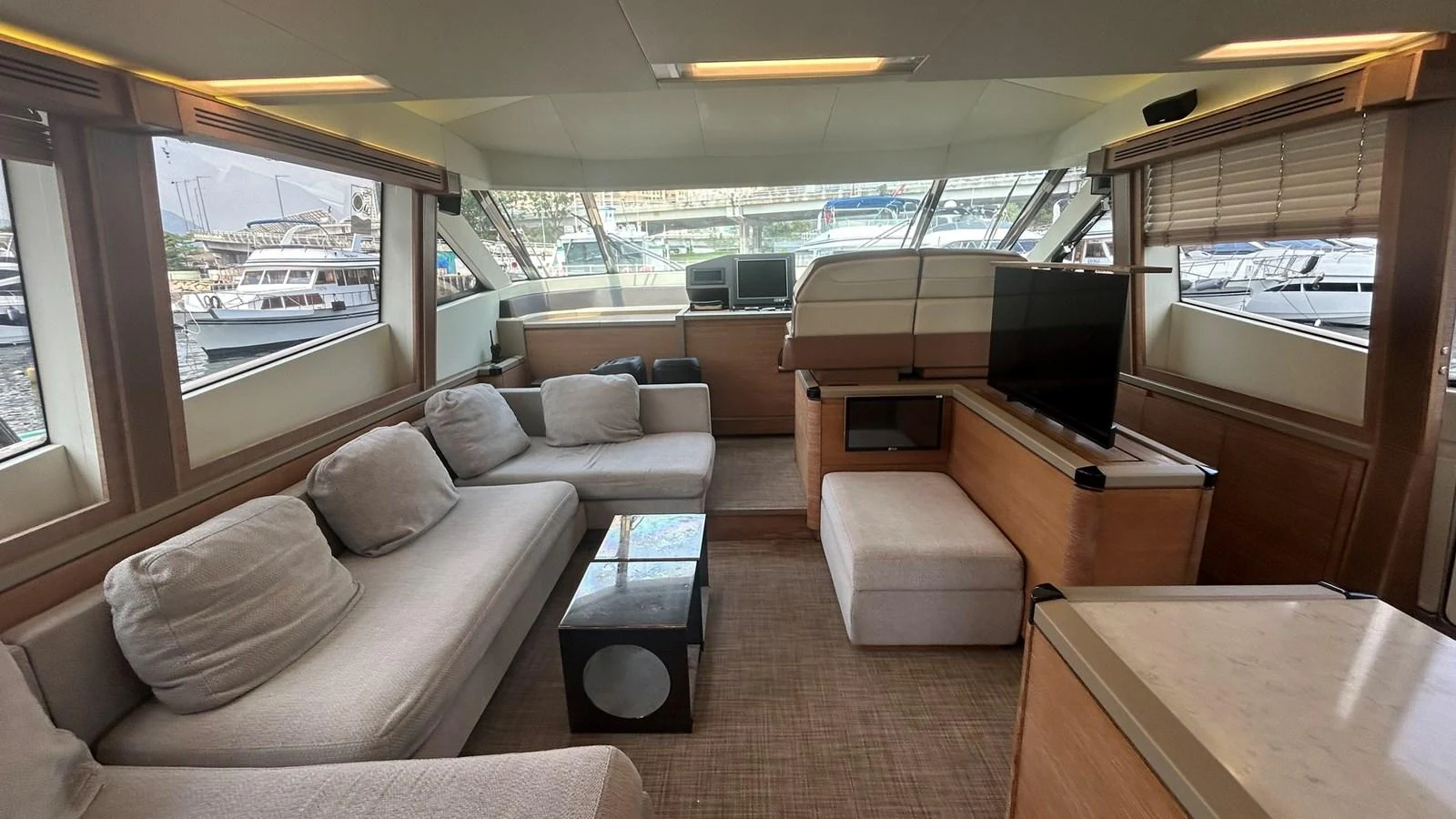 The salon features comfortable seating with large windows offering a view of the marina. aboard AURORA Yacht for Sale
