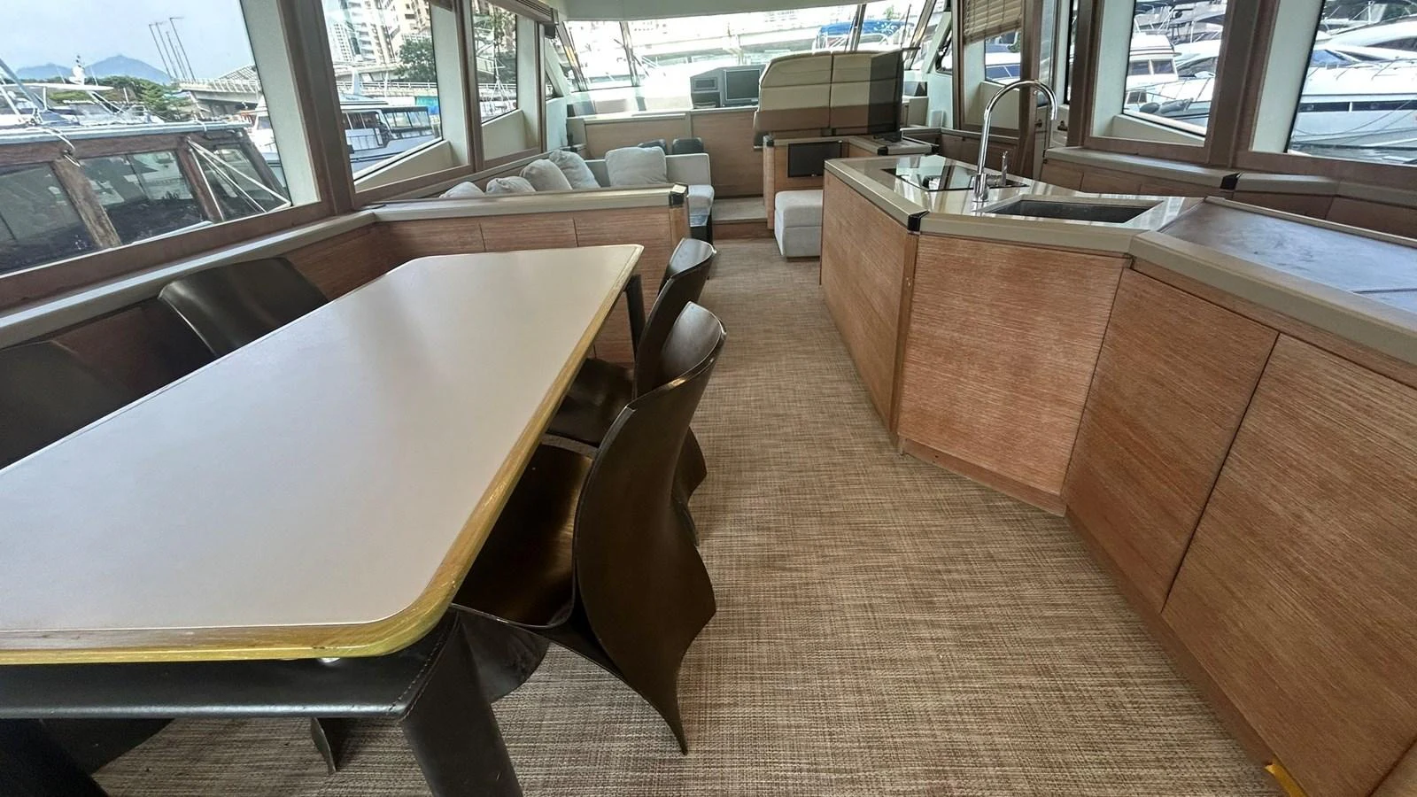 The salon features a spacious dining area with a table and comfortable seating, complemented by a modern kitchenette. aboard AURORA Yacht for Sale