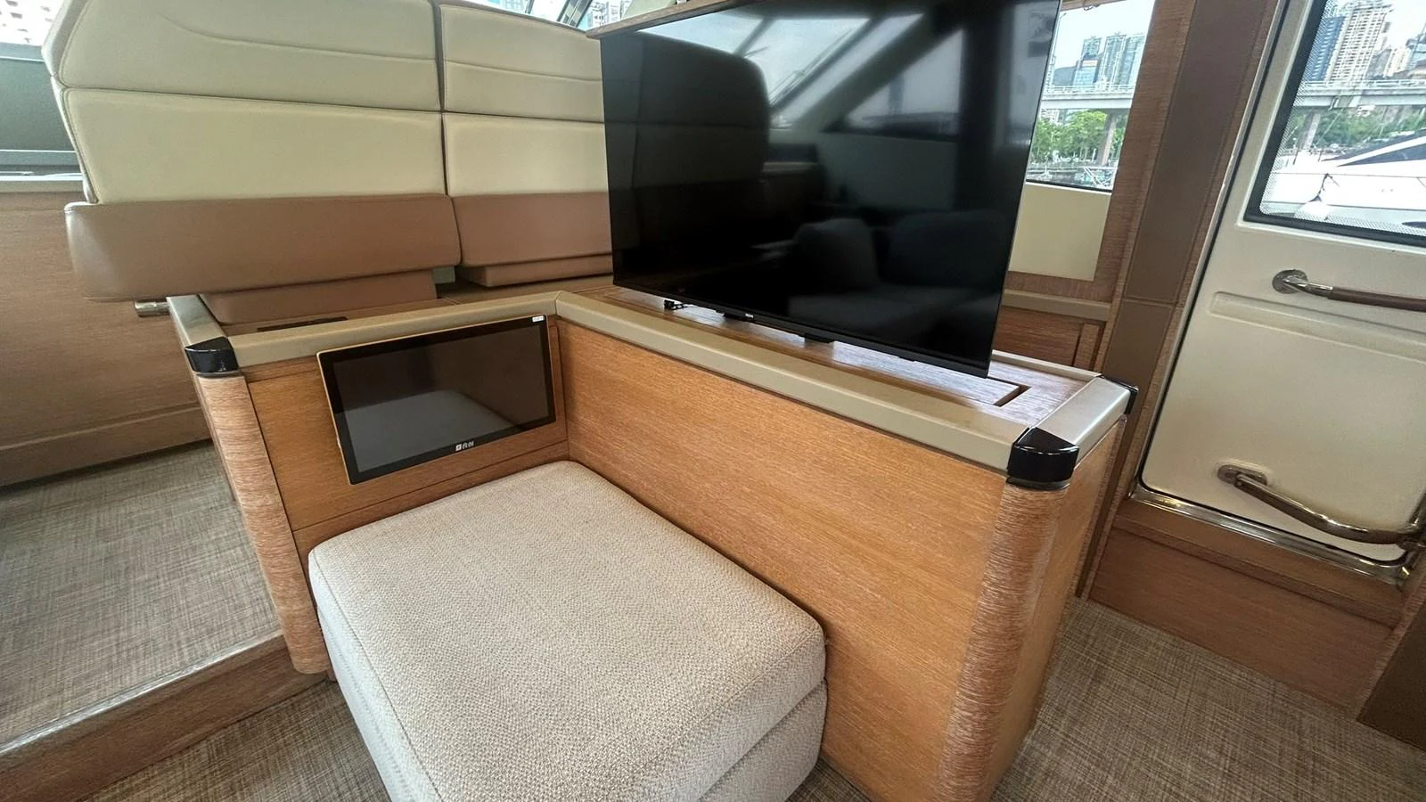 The yacht's interior features a cozy seating area with a mounted television for entertainment. aboard AURORA Yacht for Sale