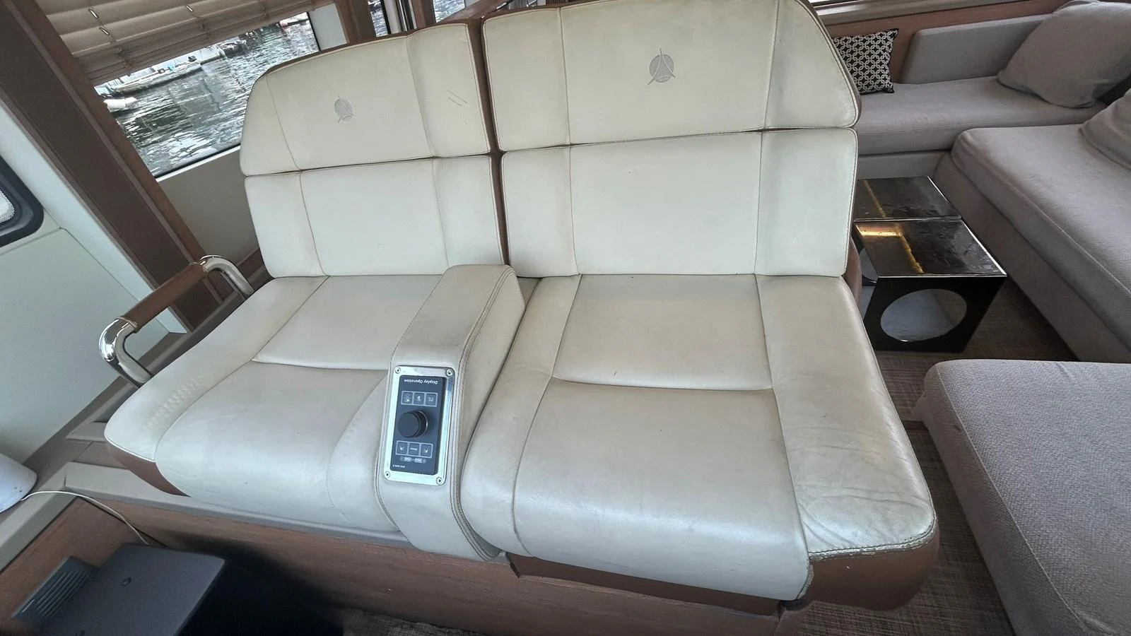 The salon features a comfortable, leather-upholstered seating area with a control panel. aboard AURORA Yacht for Sale