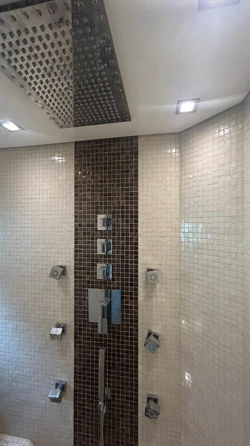 A luxurious yacht shower with modern fixtures and elegant tile work. aboard AURORA Yacht for Sale