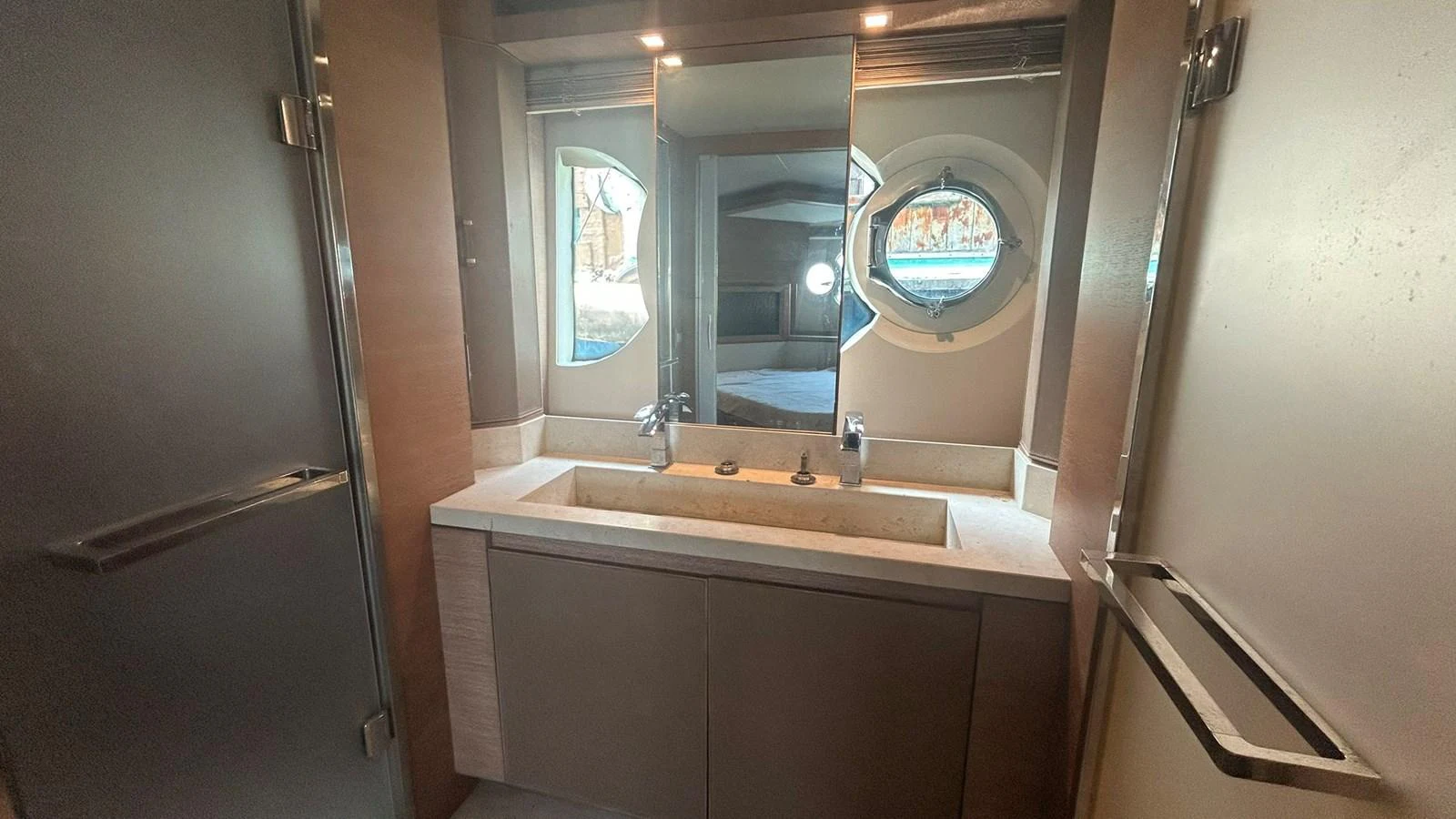 The yacht's bathroom features a sleek design with a modern sink and a porthole window. aboard AURORA Yacht for Sale