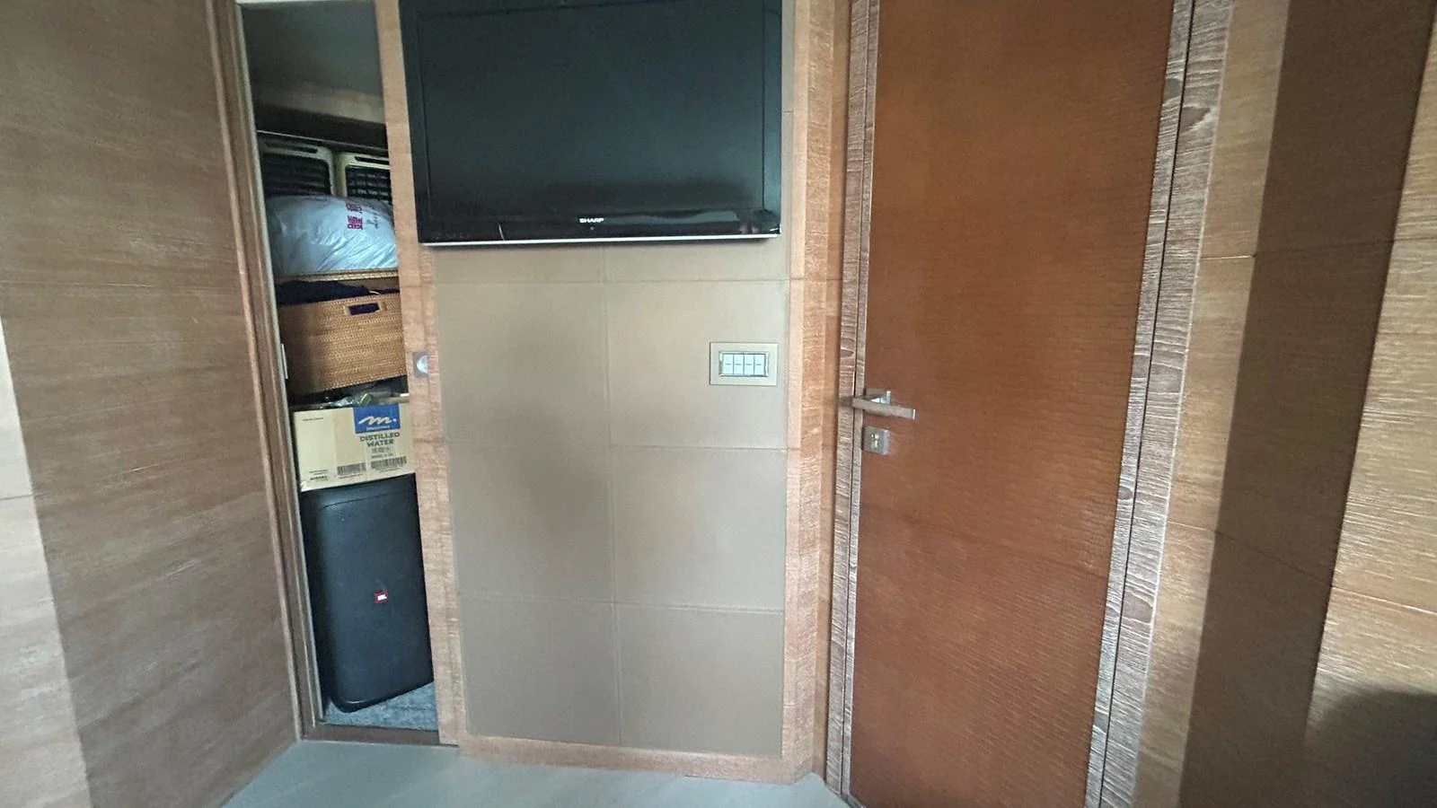 A cozy interior corner featuring a television and a door leading to a storage area. aboard AURORA Yacht for Sale