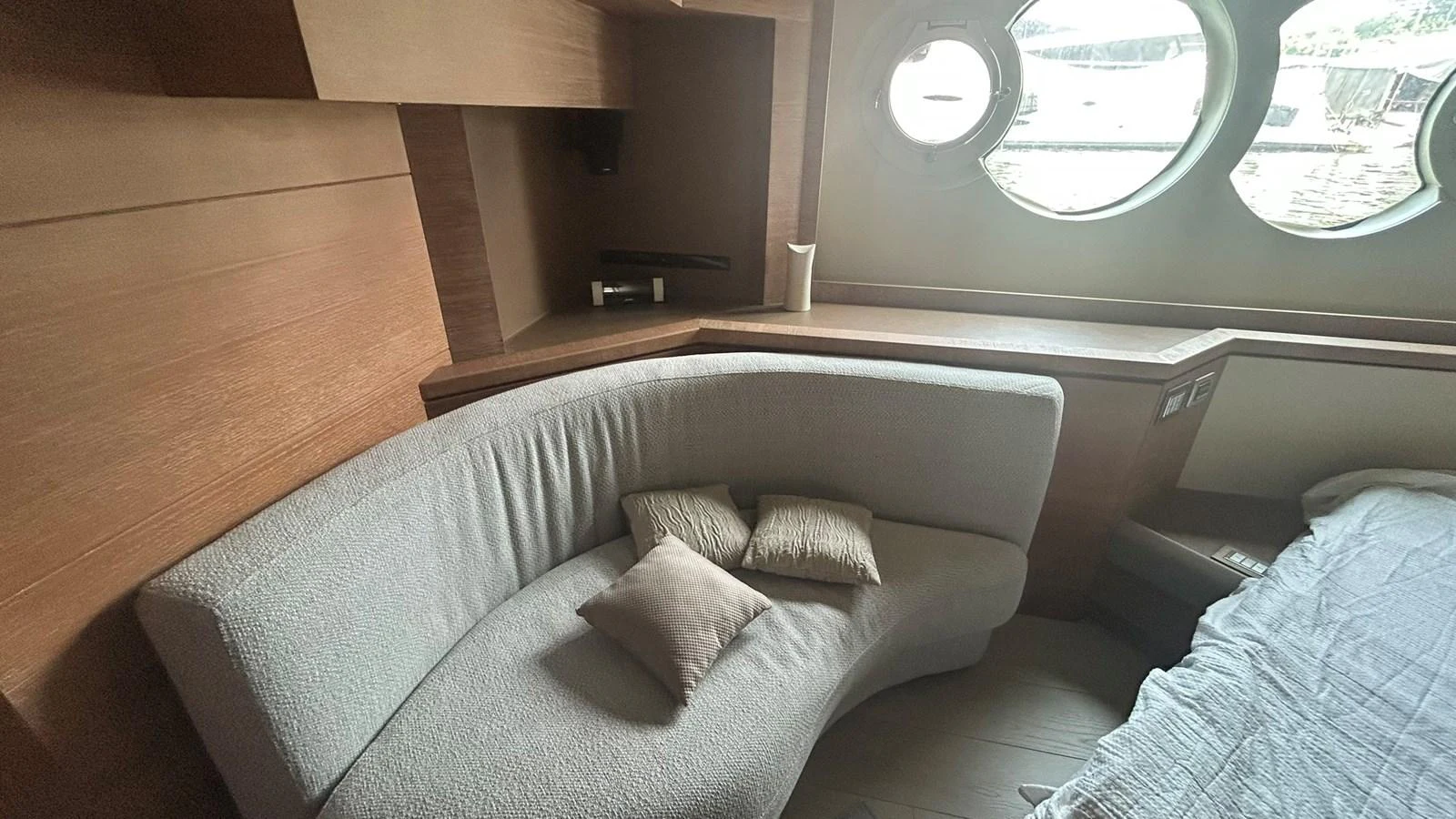 The cozy interior features a curved sofa and round windows, creating a comfortable and inviting space. aboard AURORA Yacht for Sale