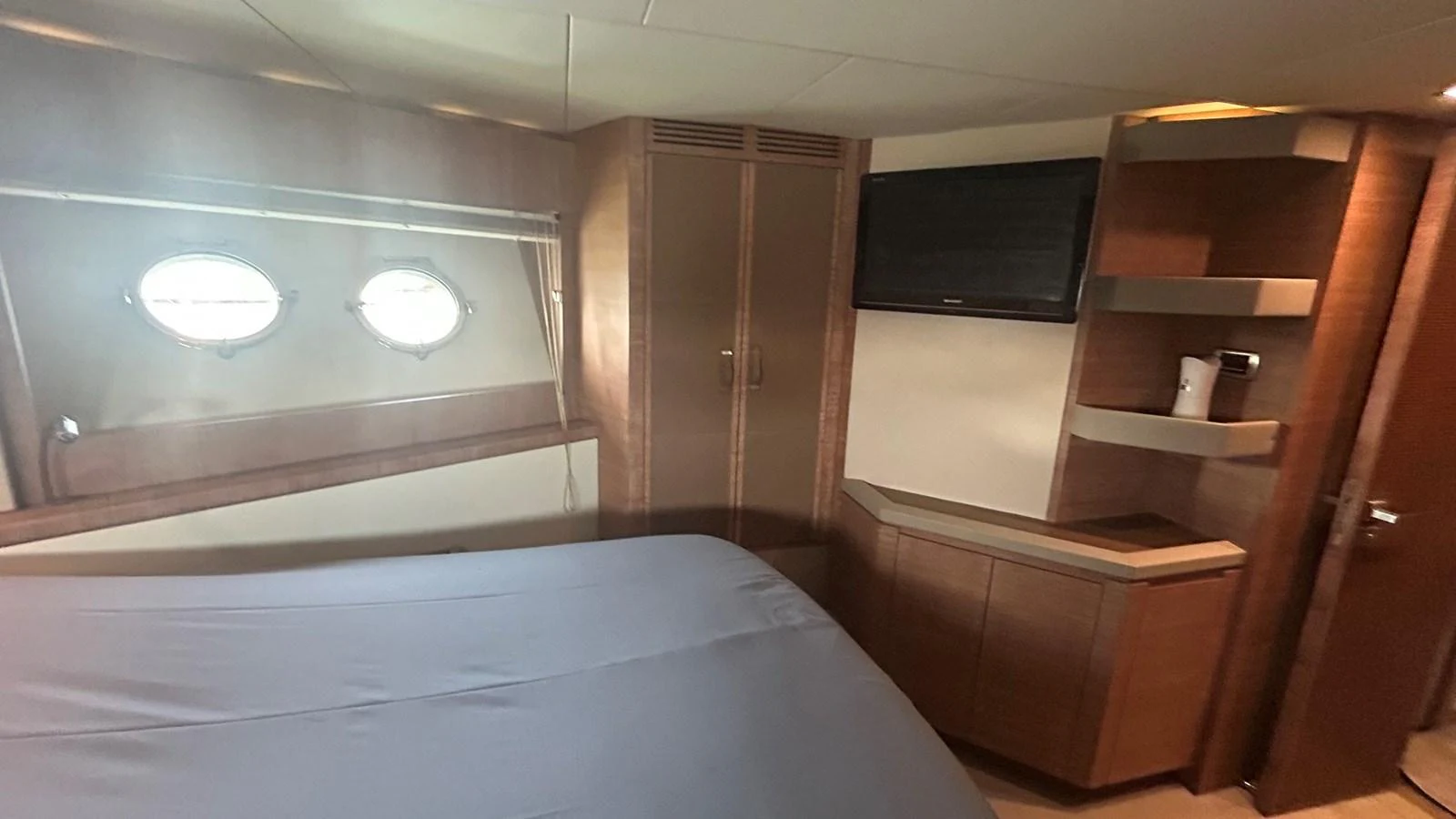 A cozy stateroom featuring a bed, portholes, and built-in storage. aboard AURORA Yacht for Sale