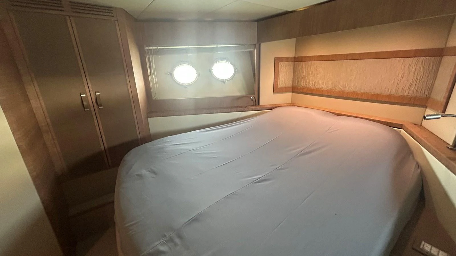 A cozy stateroom featuring a double bed and porthole windows. aboard AURORA Yacht for Sale