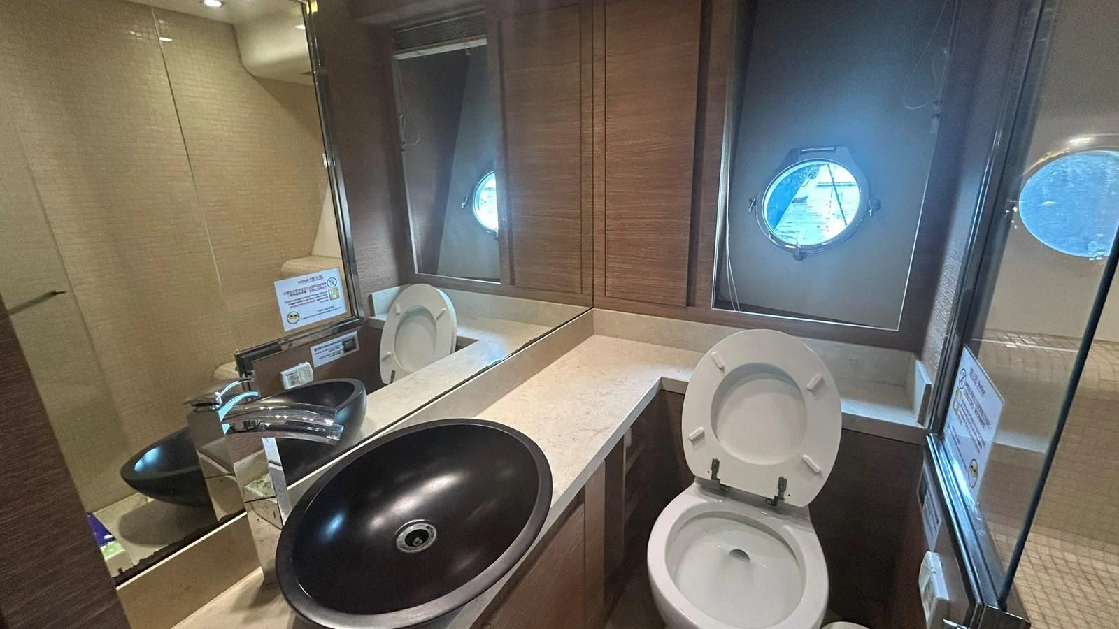 The yacht's bathroom features a modern sink and toilet with a porthole providing natural light. aboard AURORA Yacht for Sale