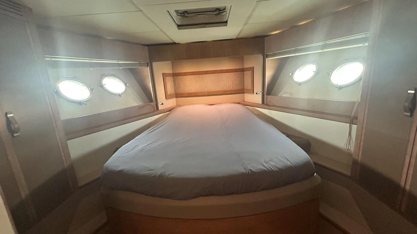 A cozy stateroom with a comfortable bed and natural light from portholes. aboard AURORA Yacht for Sale