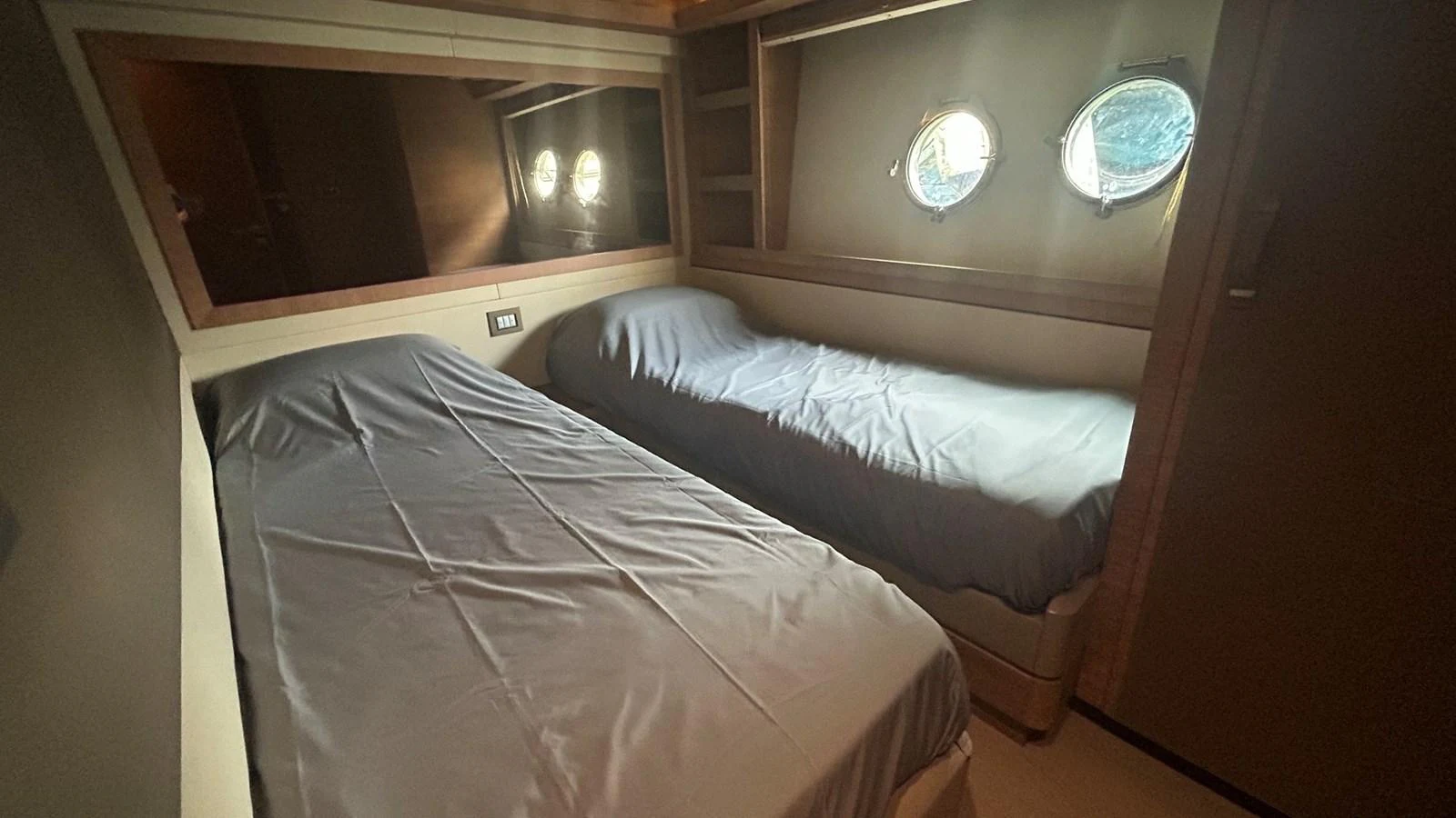 A cozy guest cabin with twin beds and porthole windows. aboard AURORA Yacht for Sale