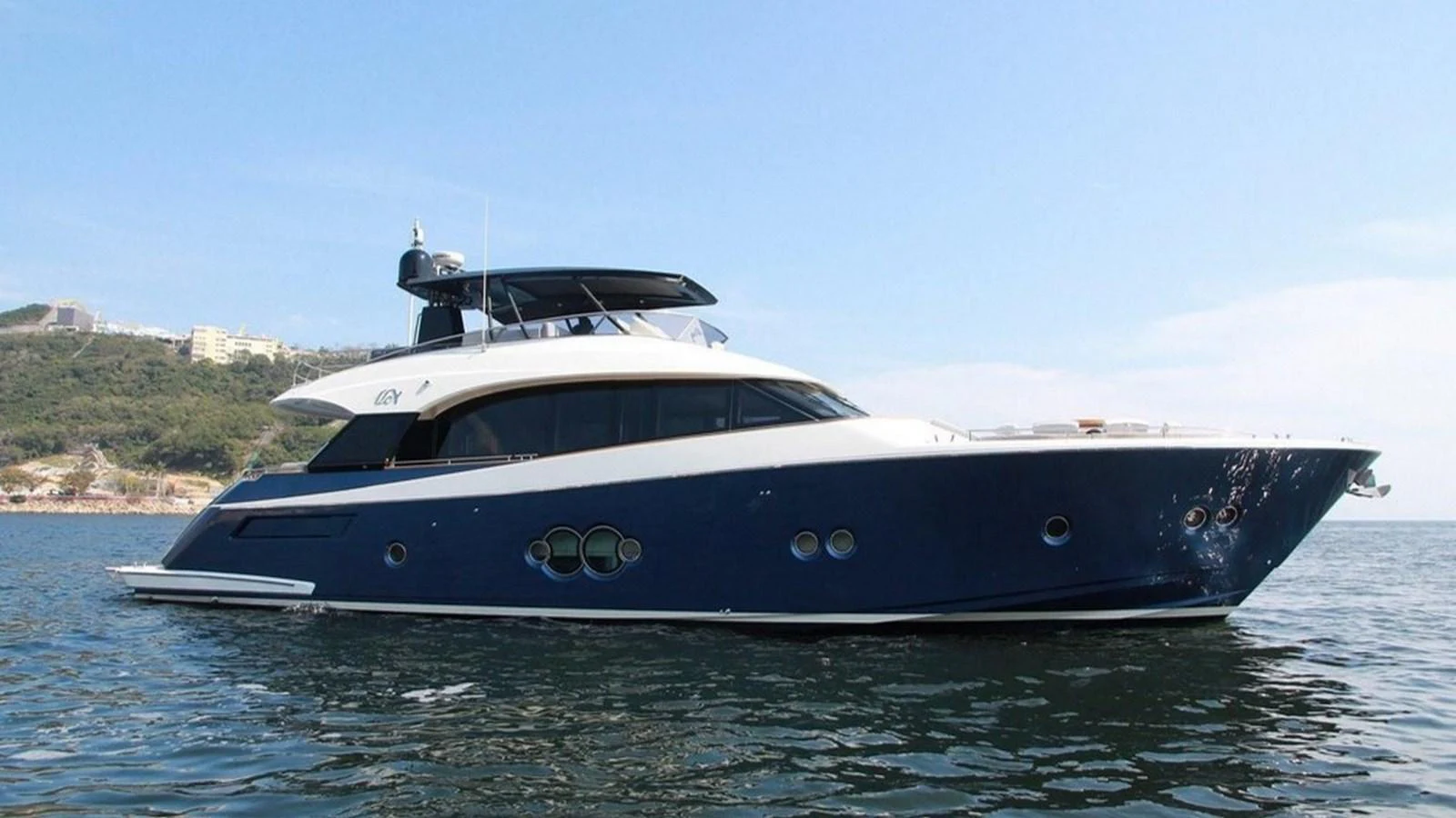 A sleek and modern yacht glides gracefully on calm waters with a scenic backdrop. aboard AURORA Yacht for Sale